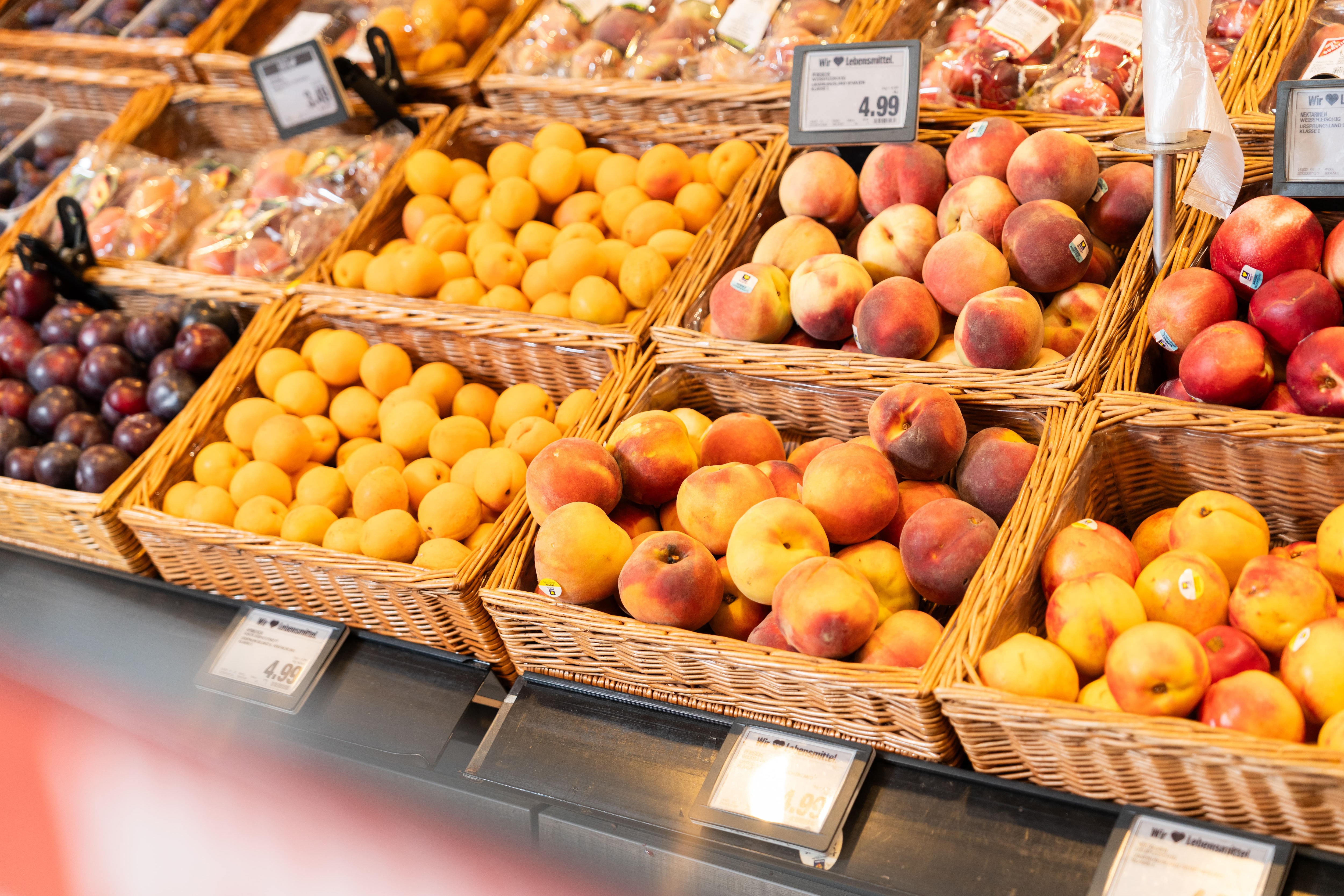 Pfirsiche, Nektarinen und Apfelsinen in Kisten.