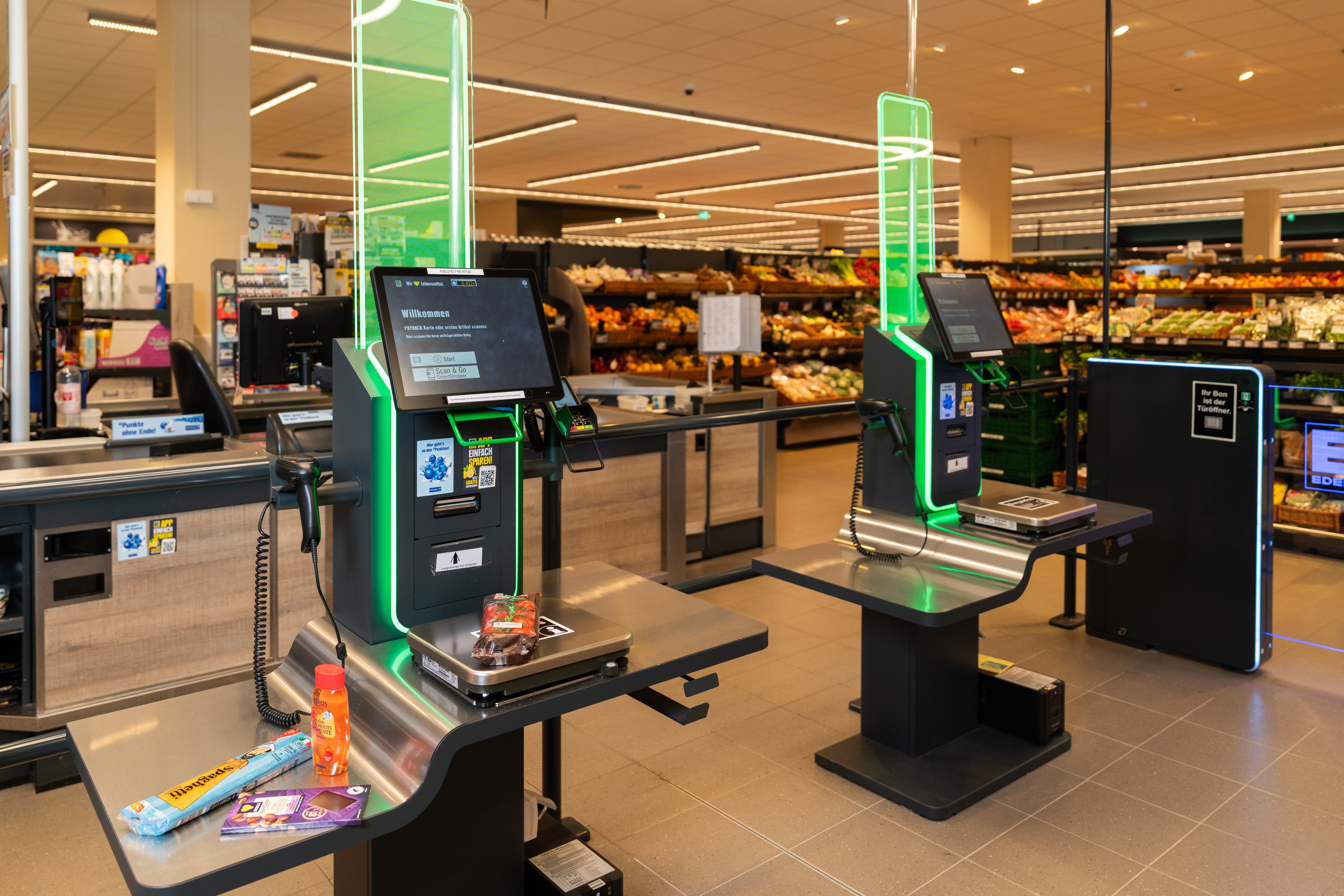 Zwei Self Scanning Kassen, die grün leuchten.