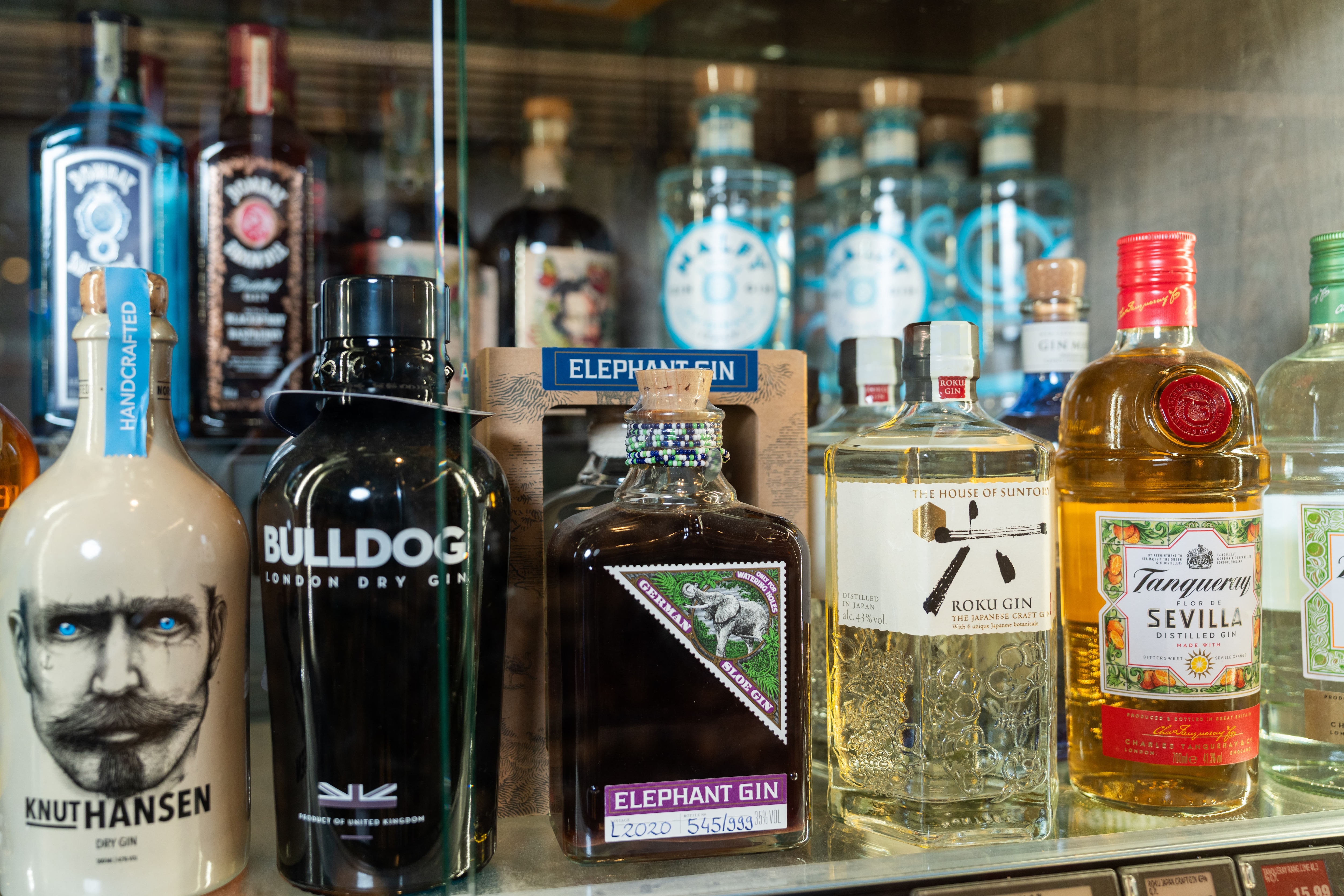 Im gläsernen Spirituosenschrank steht u.a. Gin.