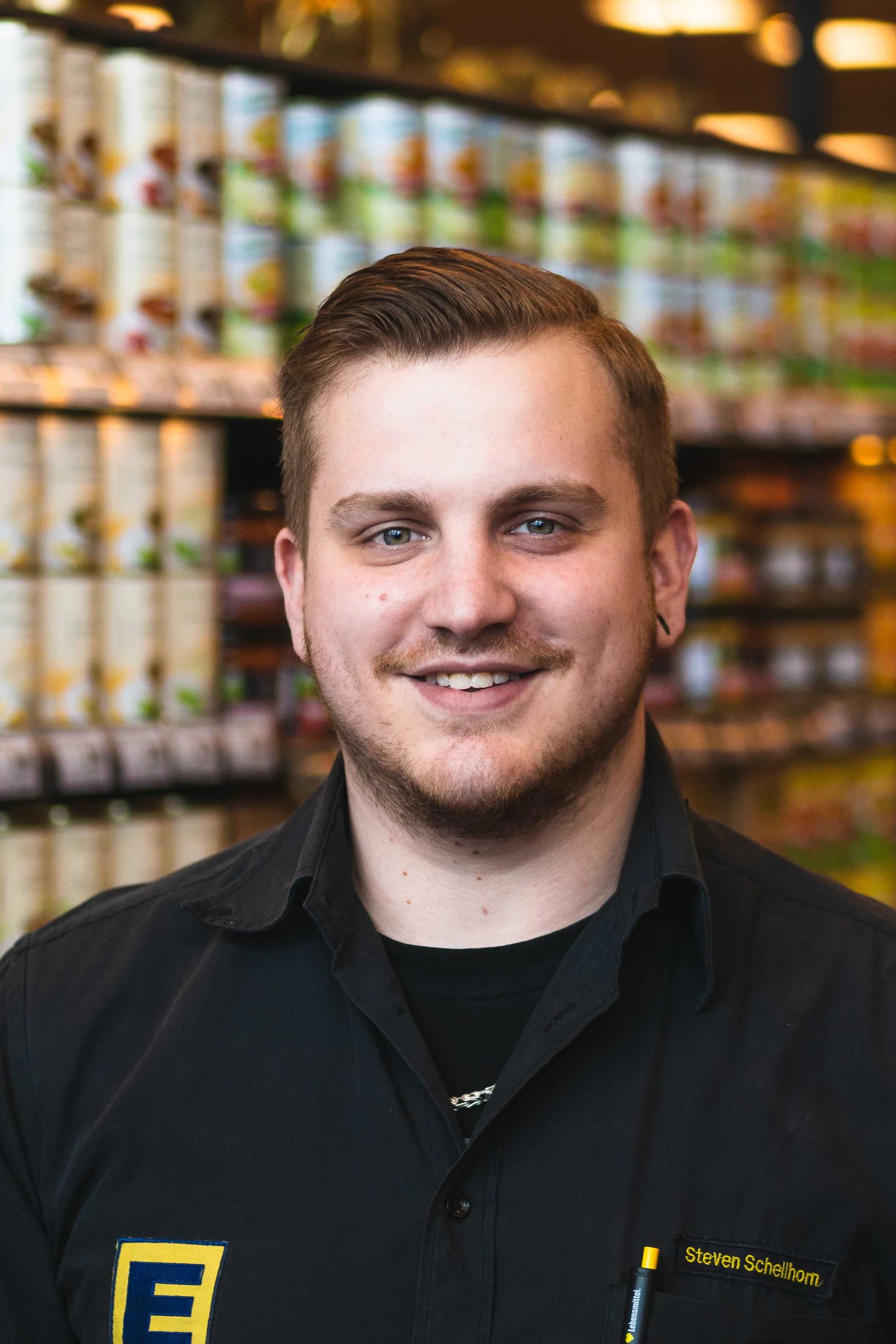 Das Portrait eines lächelnden EDEKA-Mitarbeiters.