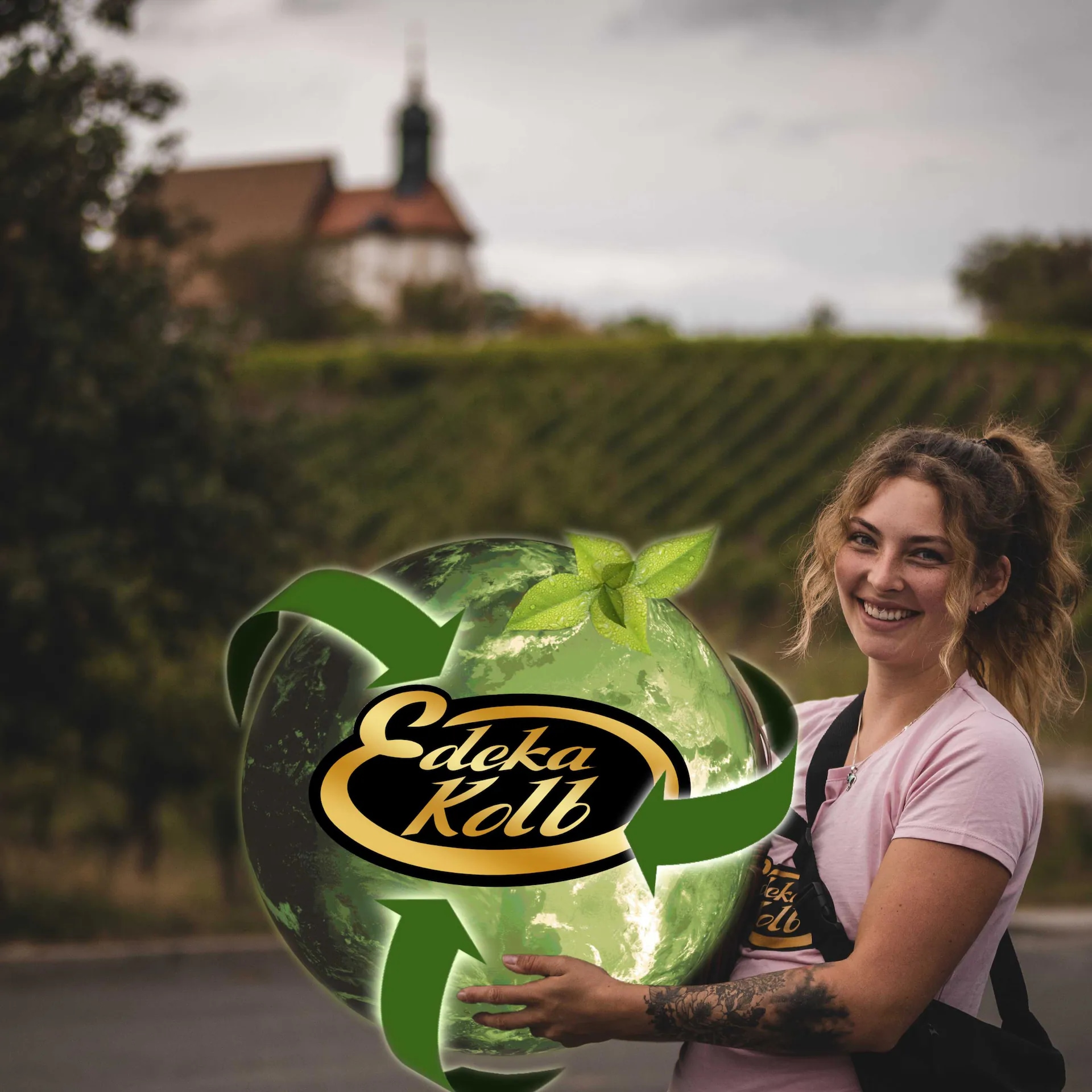 Eine lächelnde Frau hält eine animierte grüne Erde in den Händen auf der "EDEKA Kolb" steht.