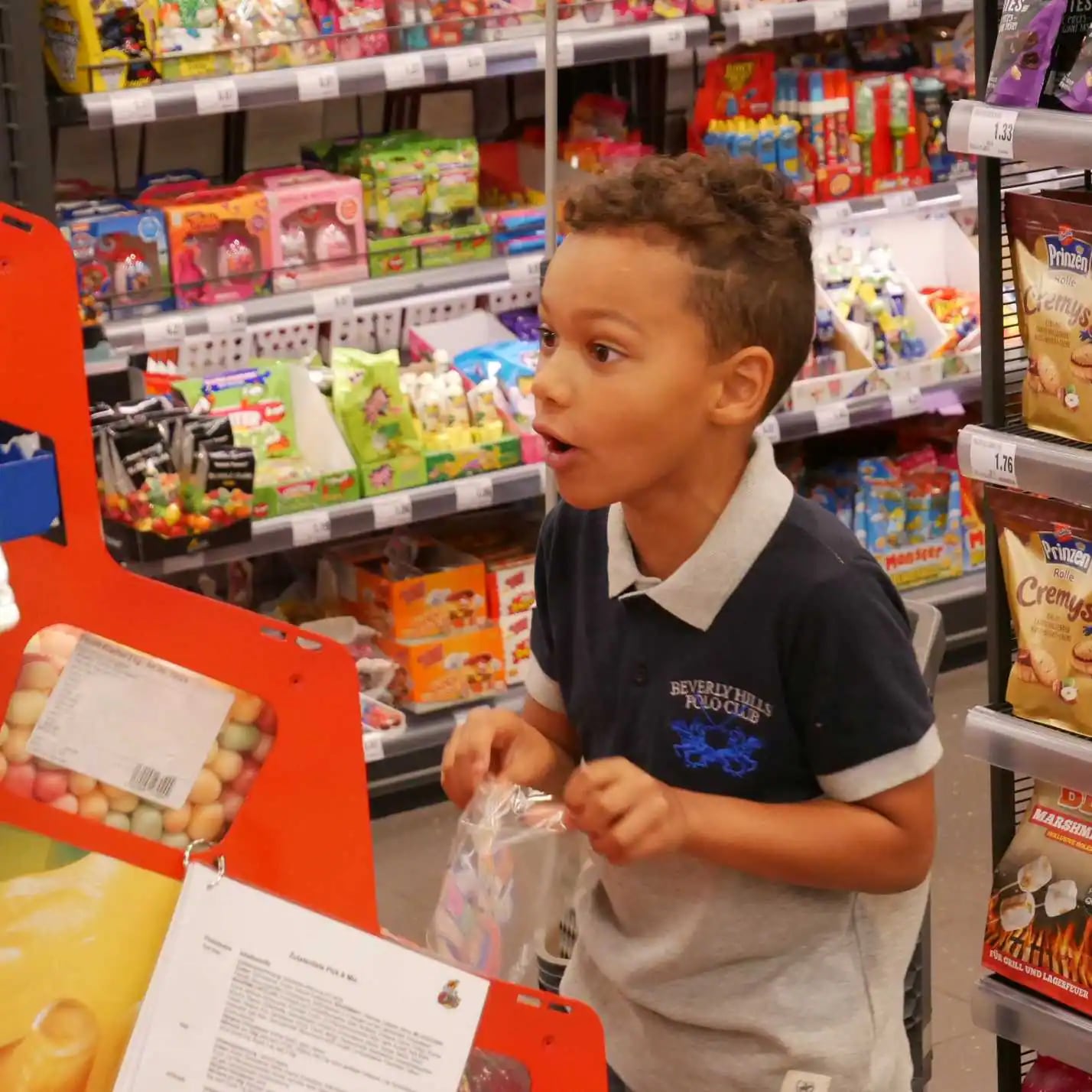 Ein Kind stellt sich eine Tüte aus verschiedenen Süßigkeiten zusammen.