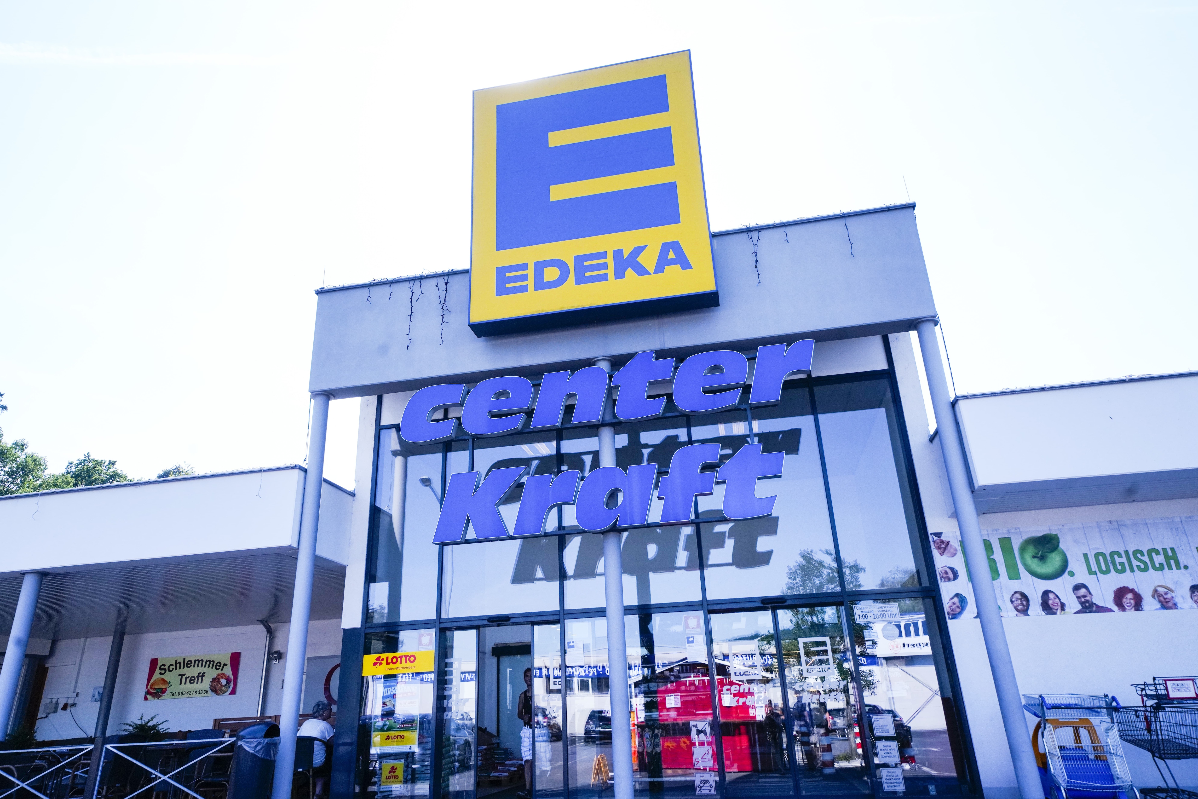Front des Markts, sonnenbeschienen, mit dem Schriftzug EDEKA über dem Eingang.