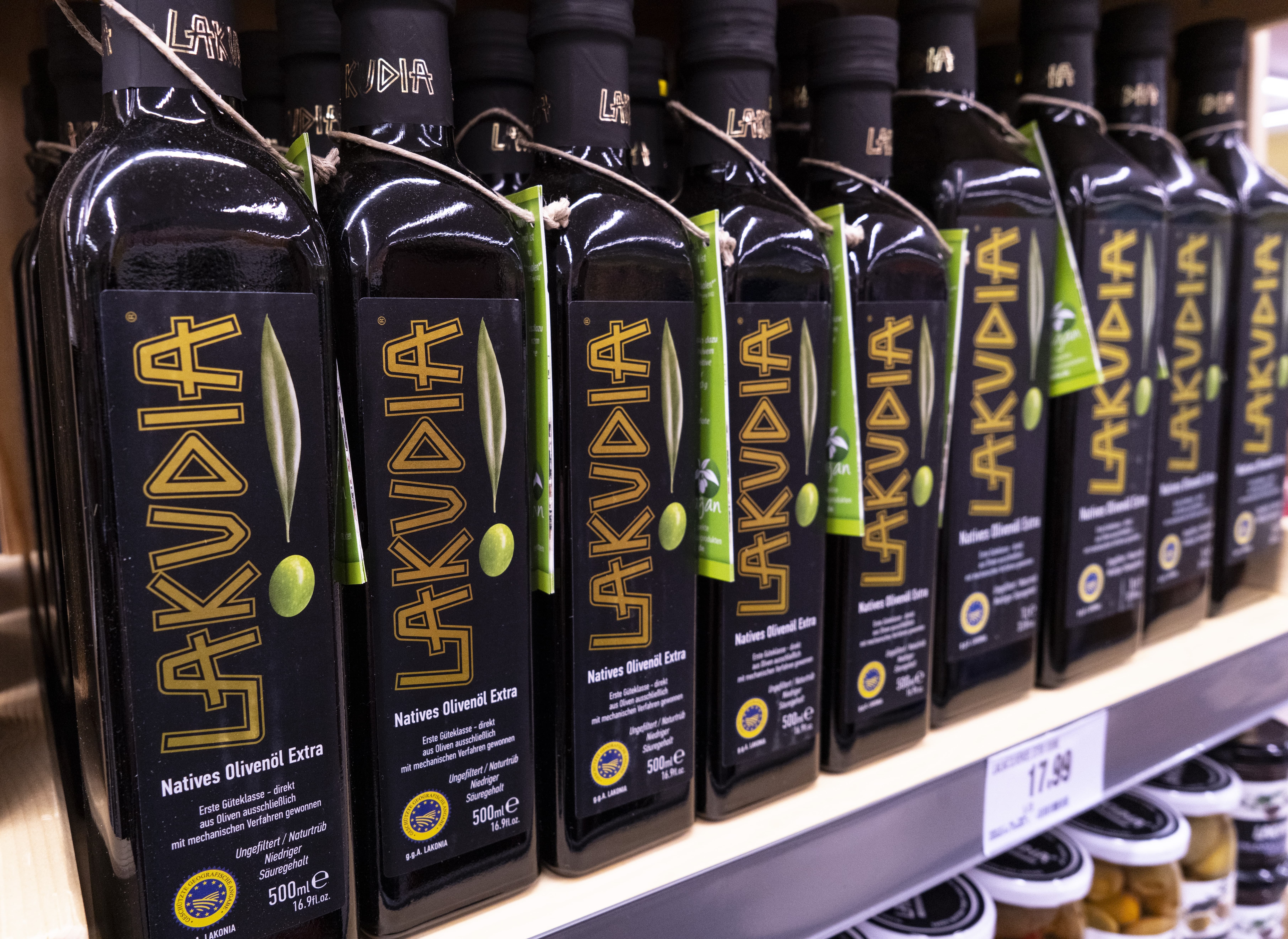 Close-Up mehrerer Flaschen Olivenöl der Marke LAKUDIA in einem Regal.