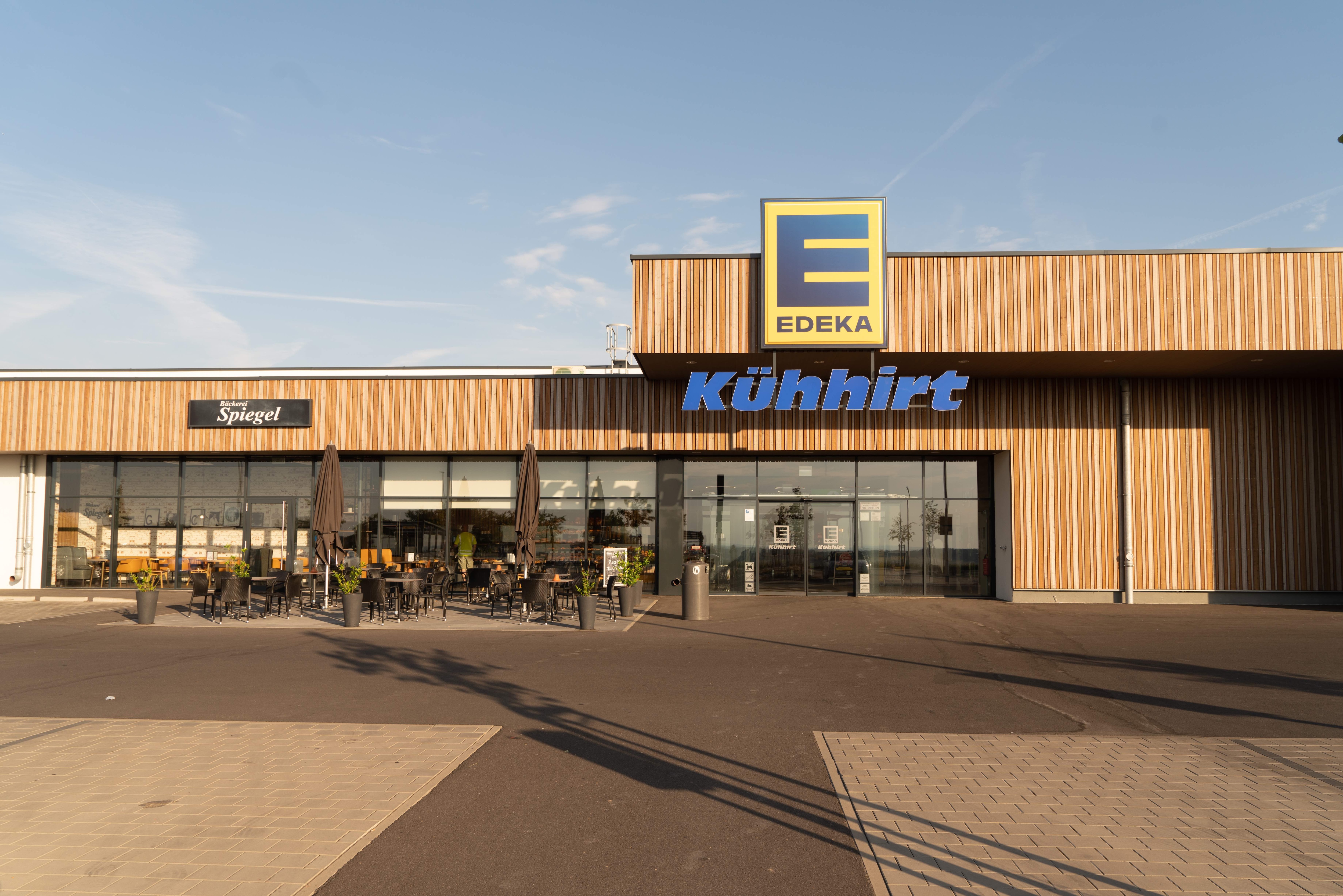 Aussenansicht Markt Kühhirt mit Parkplatz und Sitzgelegenheiten vom Cafe.