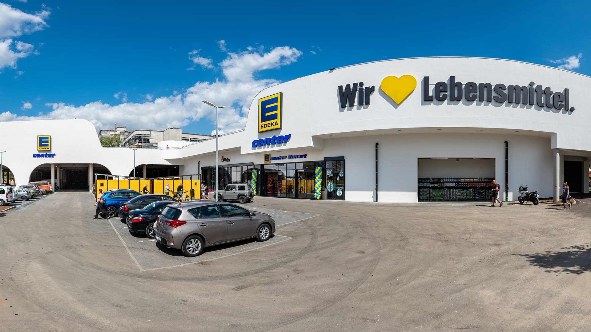 Eine Weitwinkelaufnahme eines Edeka-Centers und dessen Parkplatz.