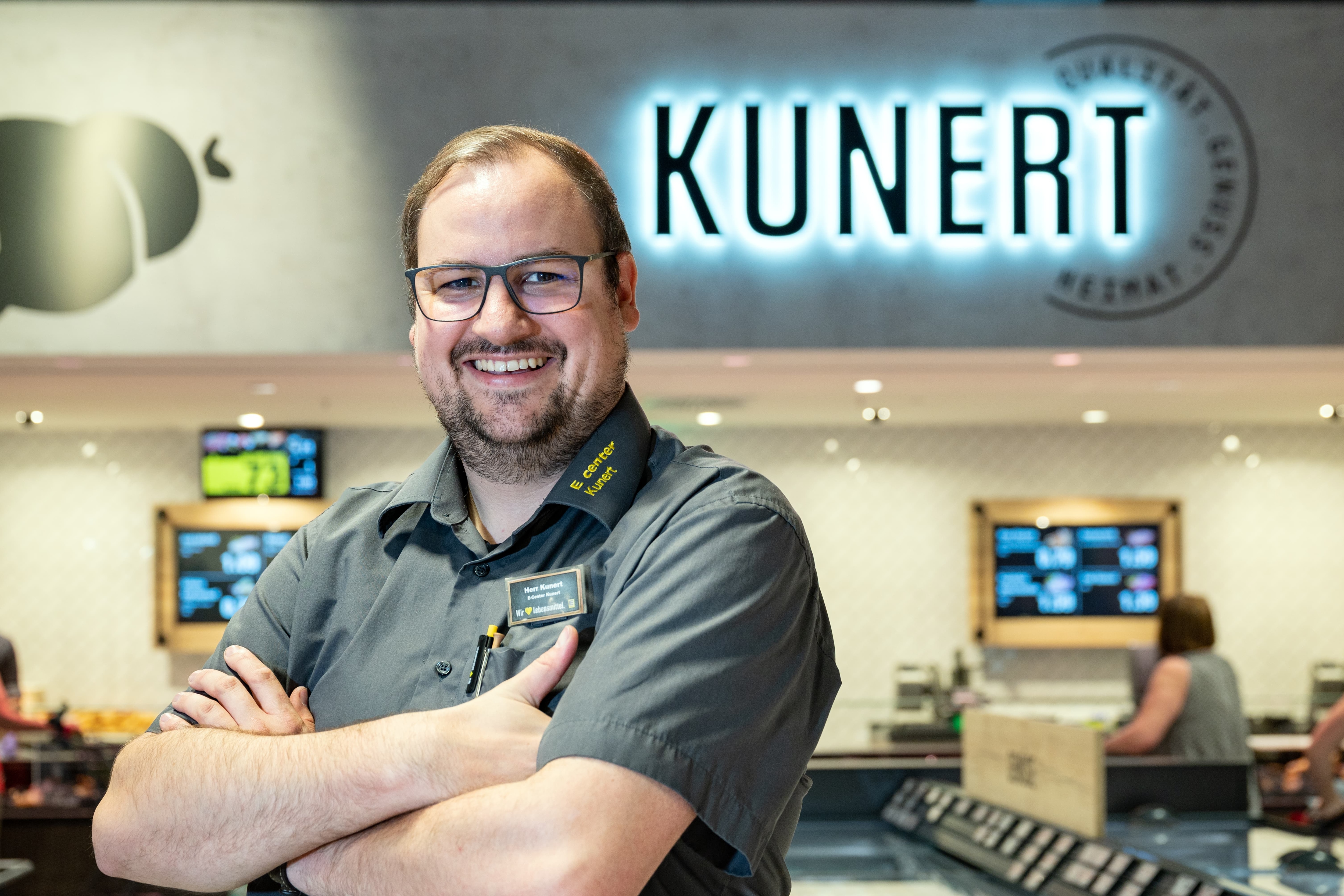 Der Inhaber eines Edeka-Marktes lächelt in die Kamera.