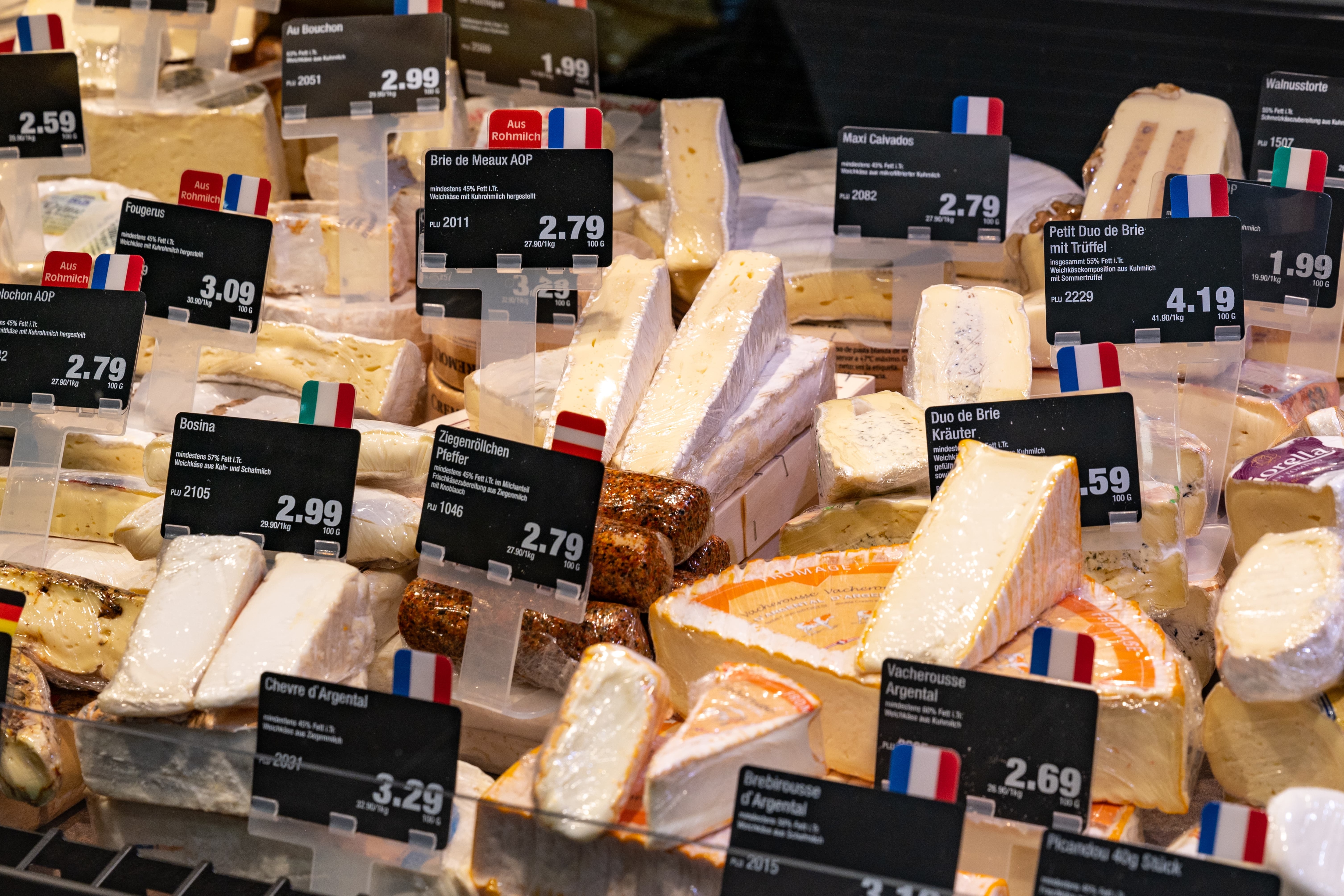 Verschiedene Käsesorten in der Auslage einer Bedientheke.