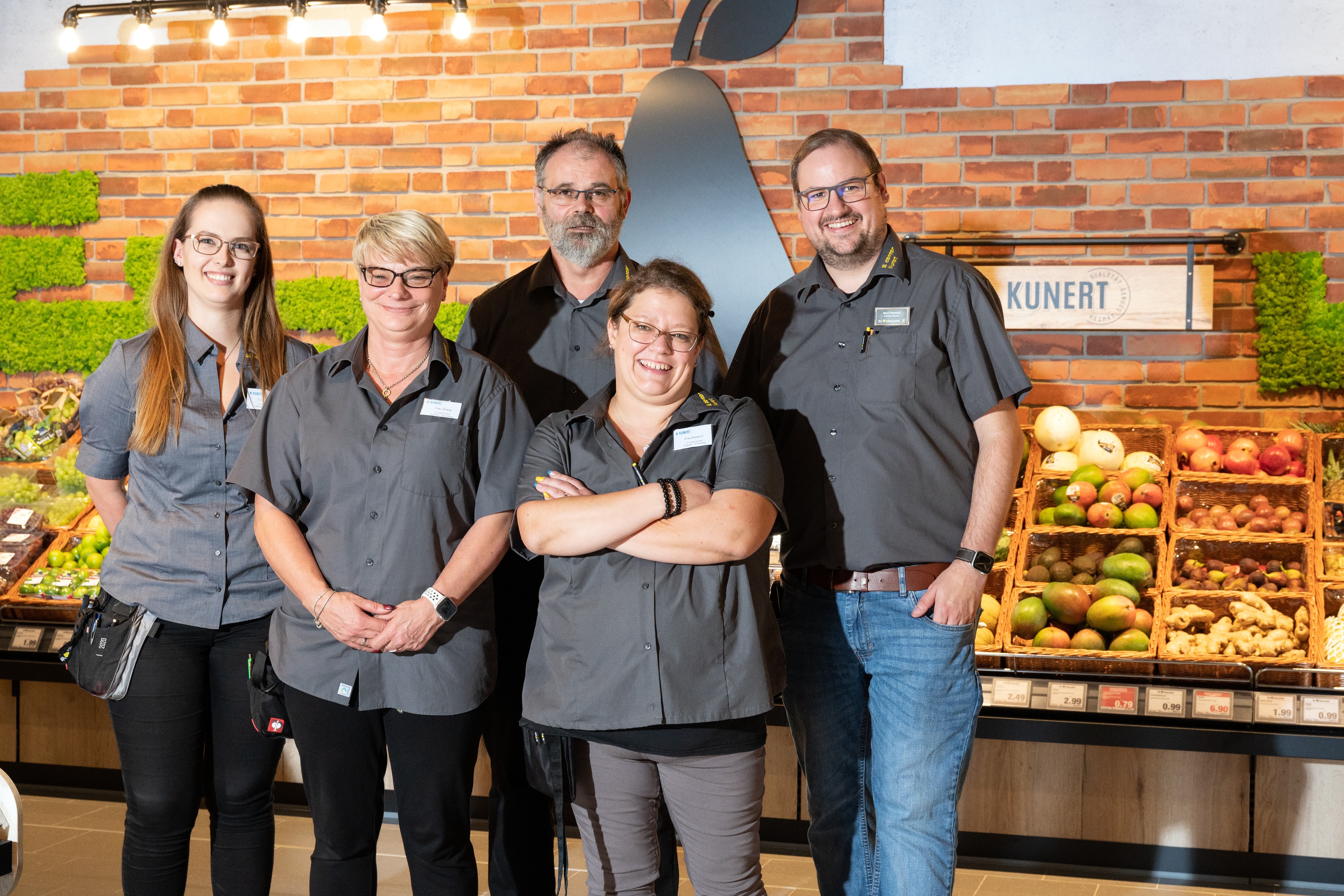 Gruppenfoto von fünf lächelnden Mitarbeitenden in der Gemüseabteilung eines Edeka-Marktes.