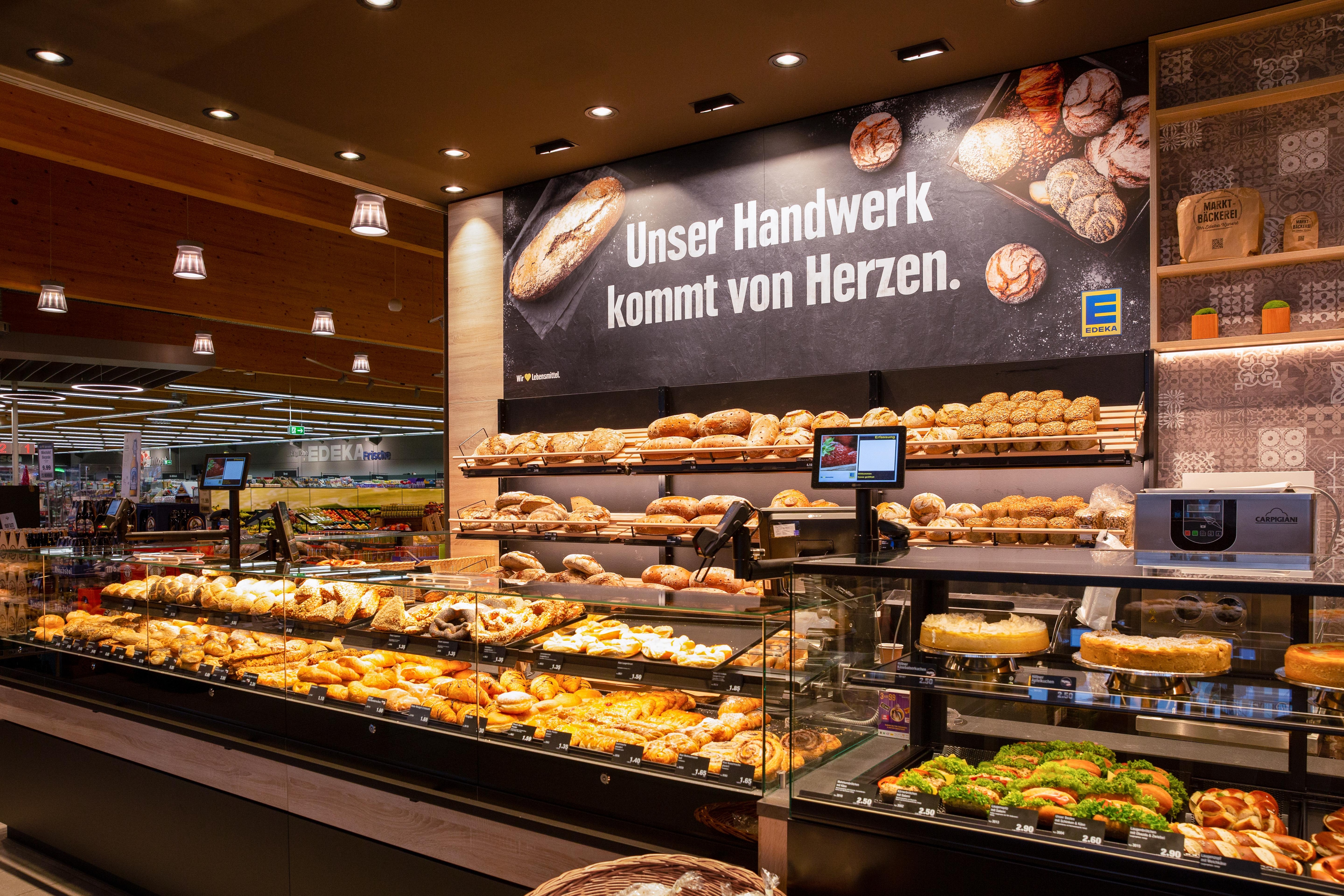 Ein Bäcker im Eingangsbereich eines Edeka-Marktes.