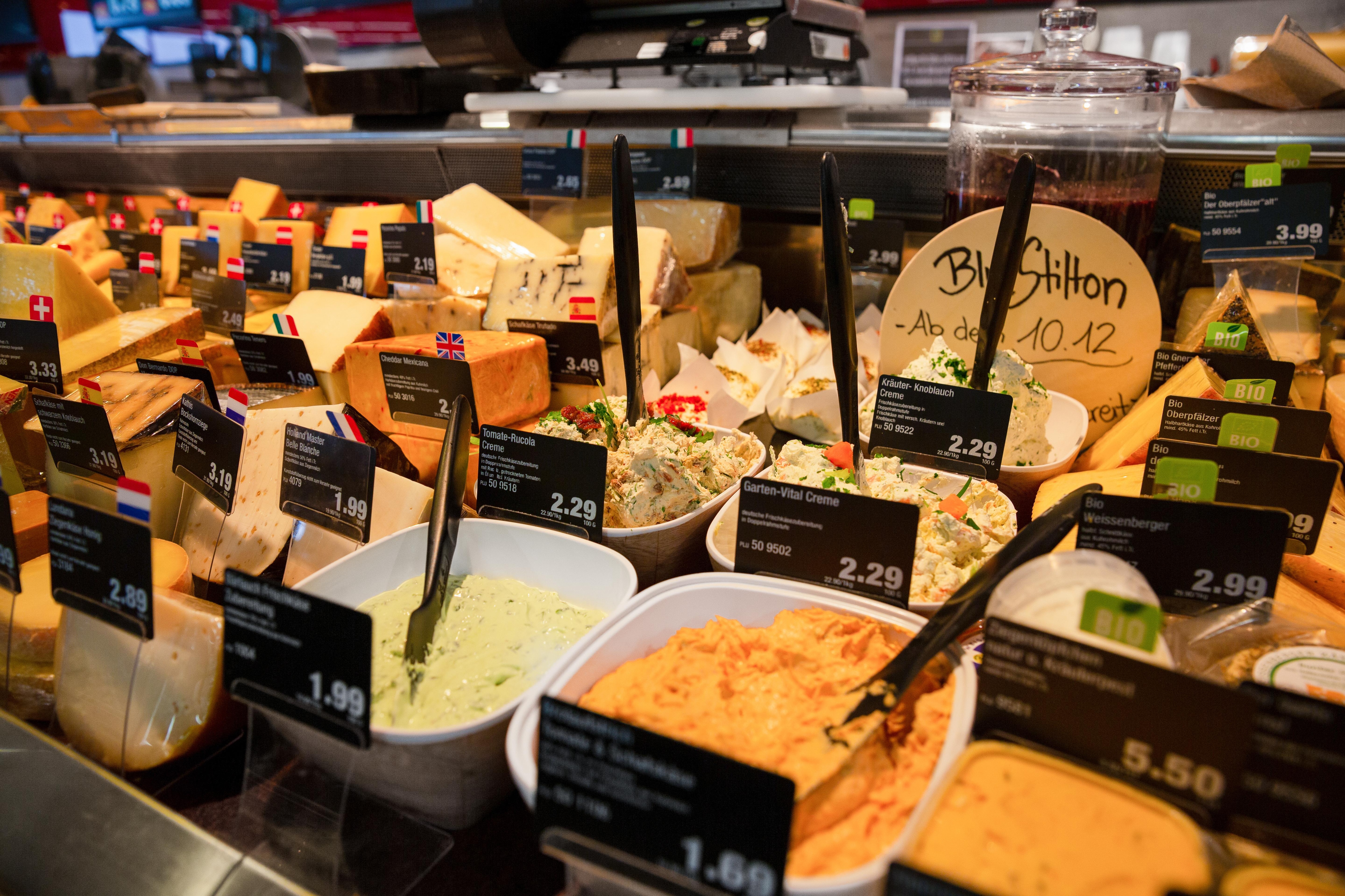 Die Käsetheke eines Edeka-Marktes. Im Fokus: Schüsseln mit verschiedenen Frischkäse-Cremes.