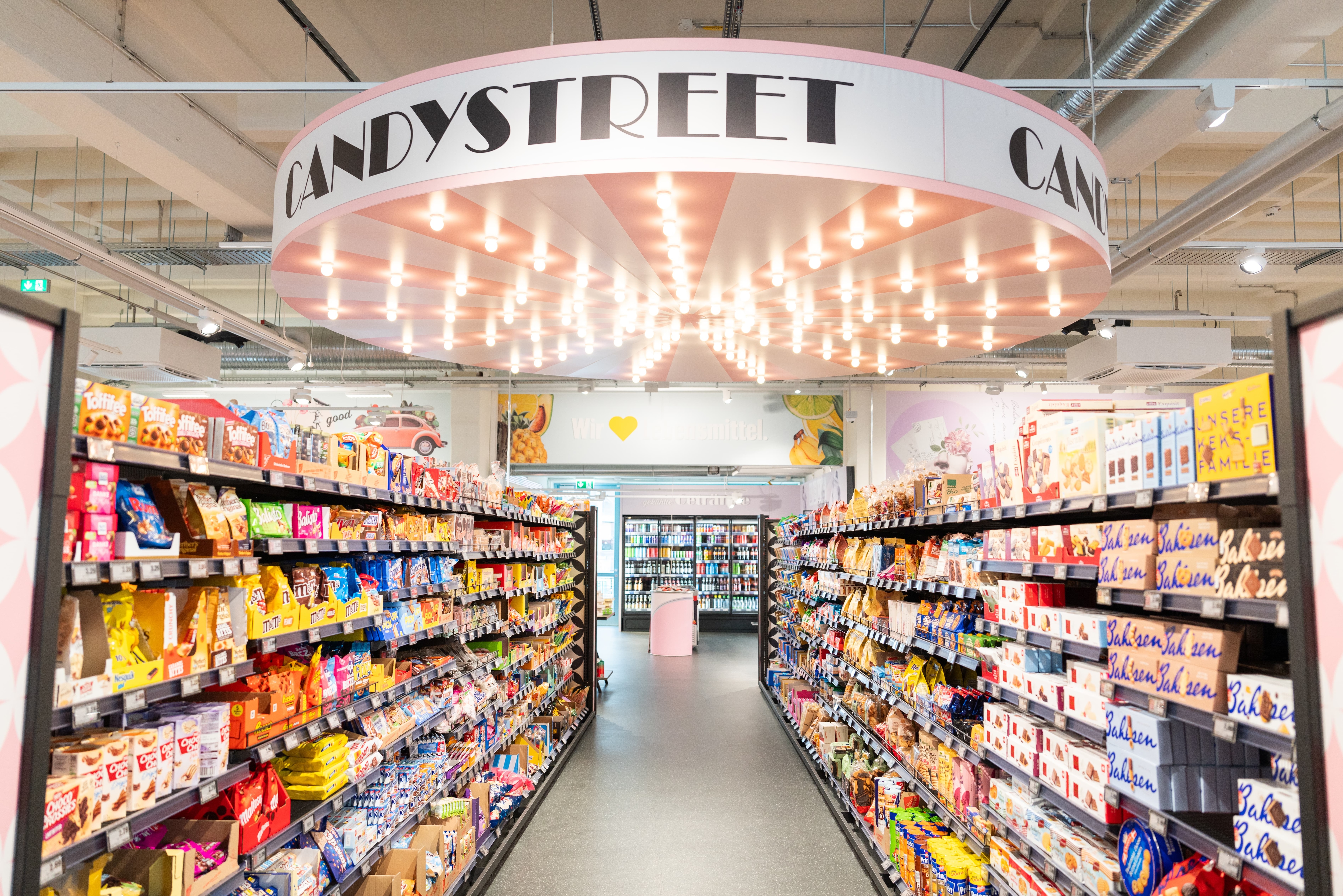 Eine Süßwarenabteilung über der eine Lichtinstallation mit der Aufschrift "Candystreet" hängt.