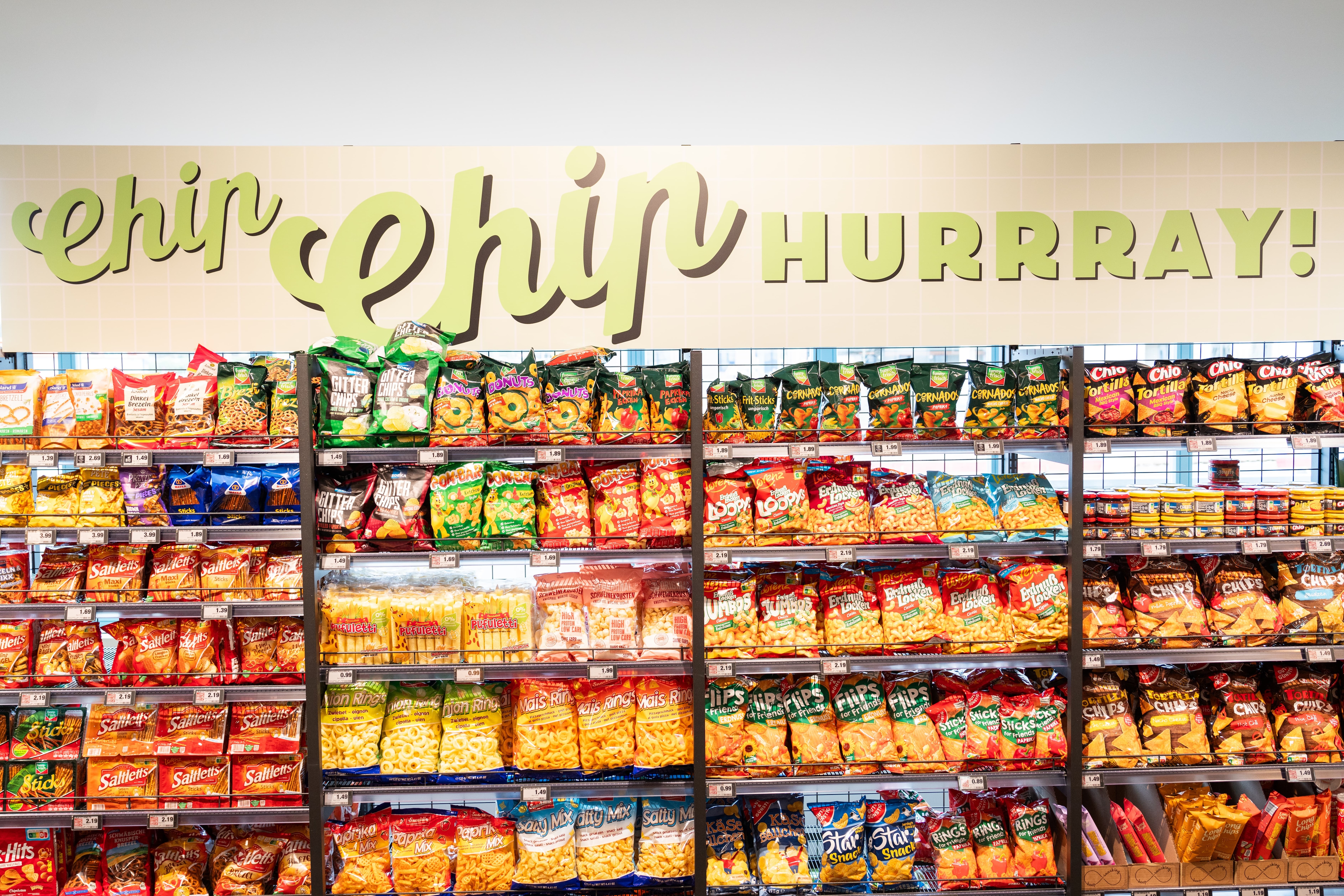 Ein Regal mit Chips über dem ein Schild mit der Aufschrift "Chip Chip Hurray" angebracht ist.