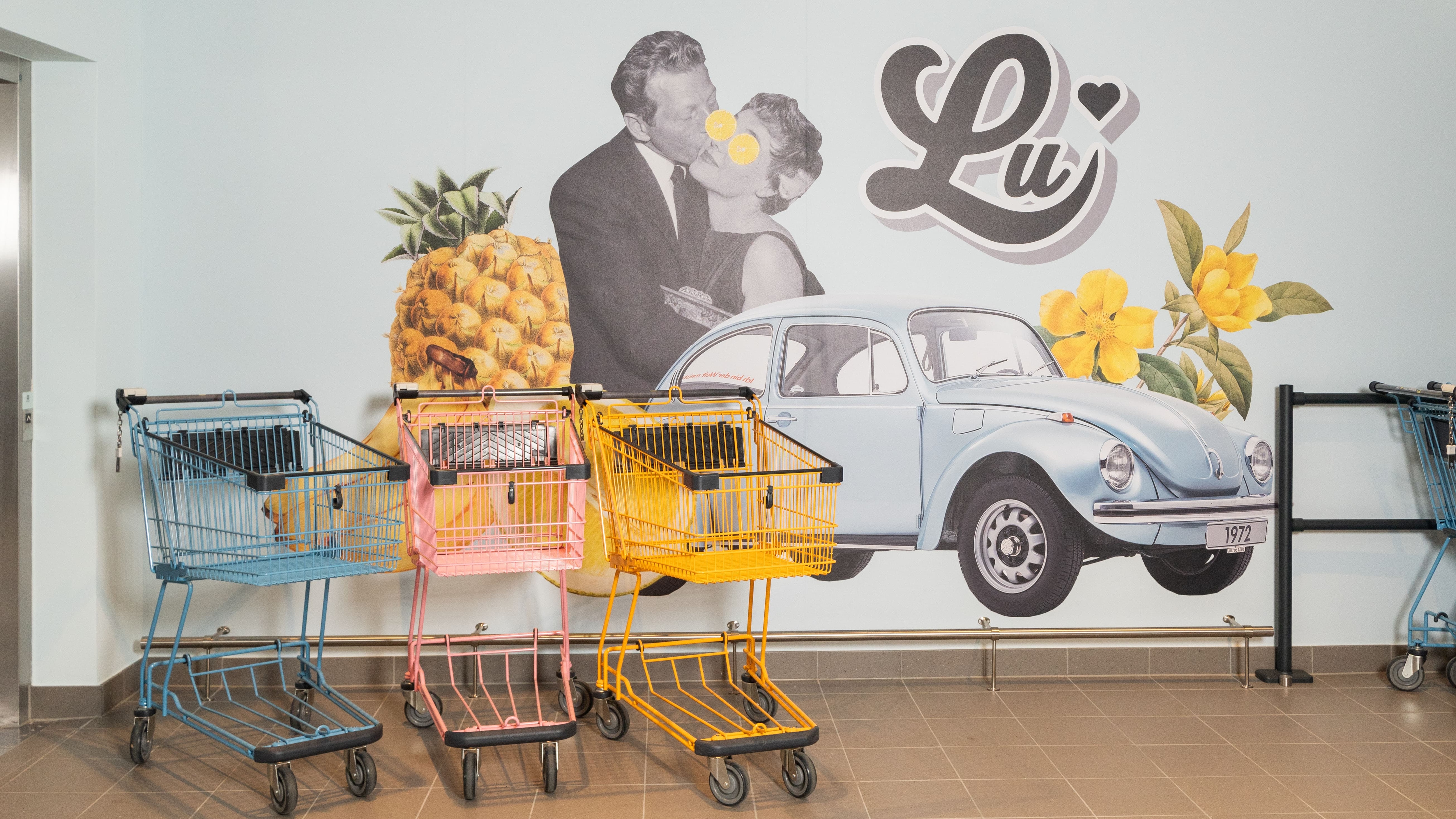 Drei verschieden farbige Einkaufswagen.