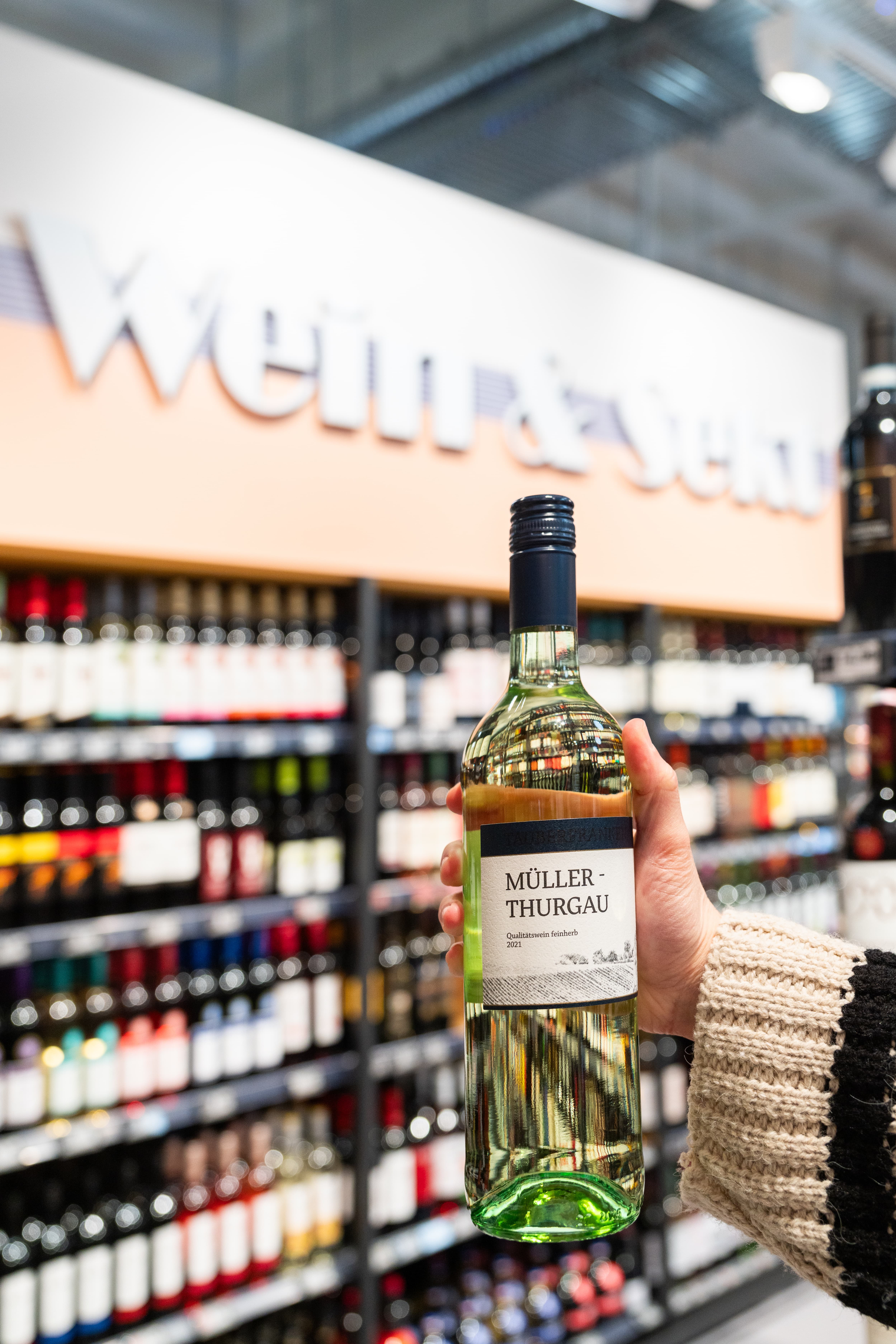 Eine Hand hält eine Flasche Wein.