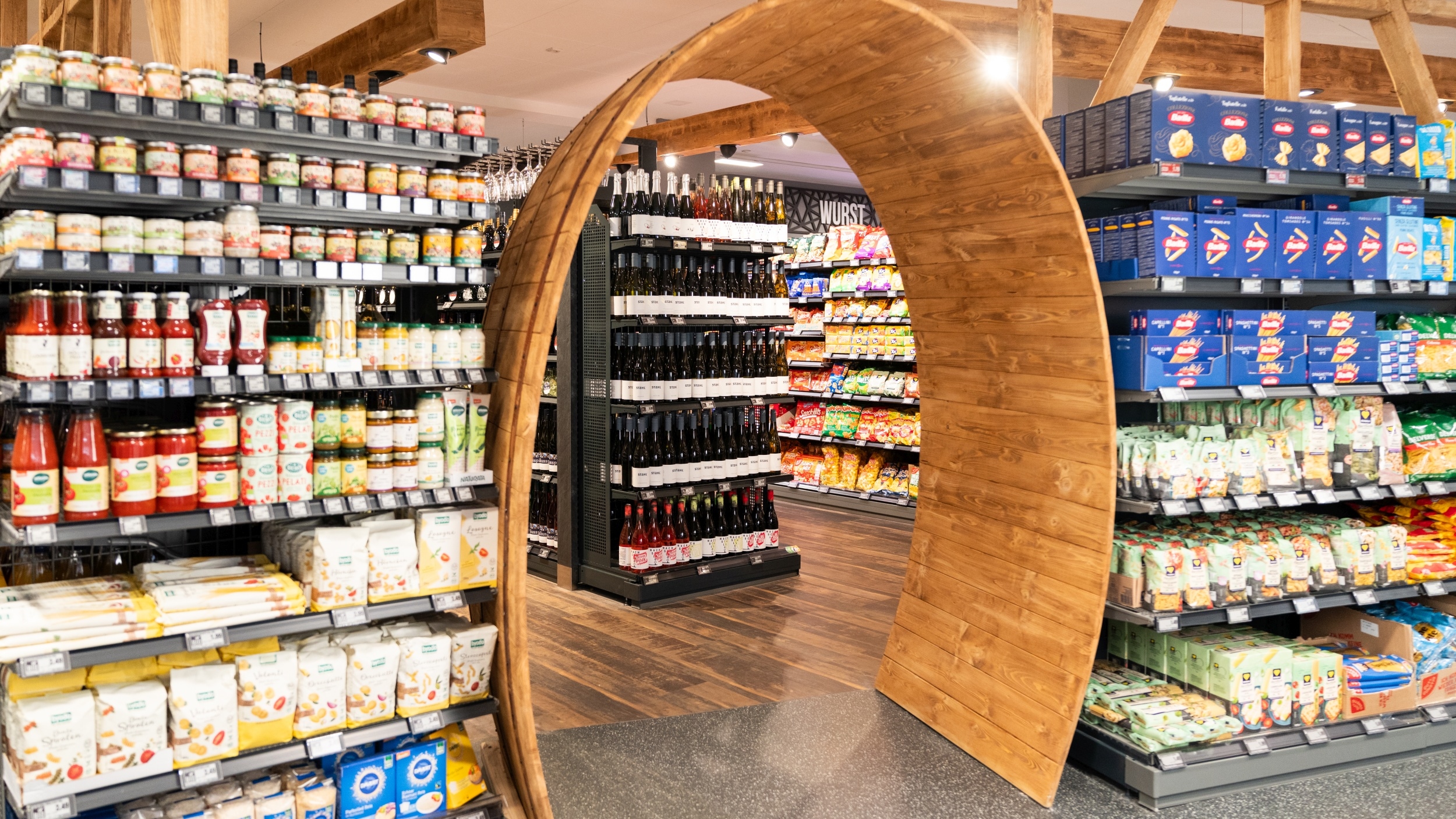 Durchgang in Form eines Weinfasses zur Weinabteilung