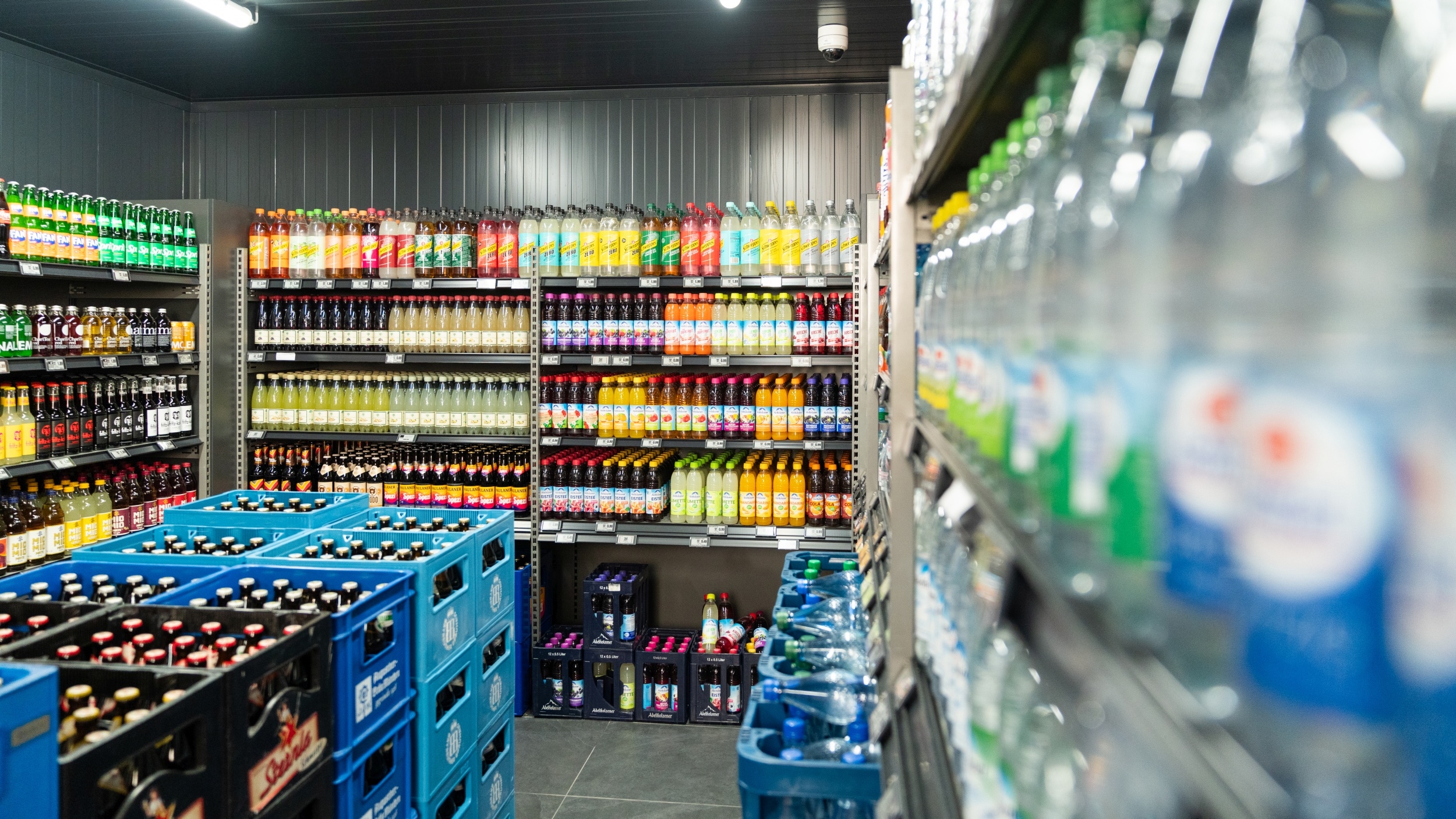 Blick auf den Bereich mit Erfrischungsgetränken. In der Mitte des Bereiches sind unterschiedliche Bier-Sorten und -Marken in Getränkekisten positioniert