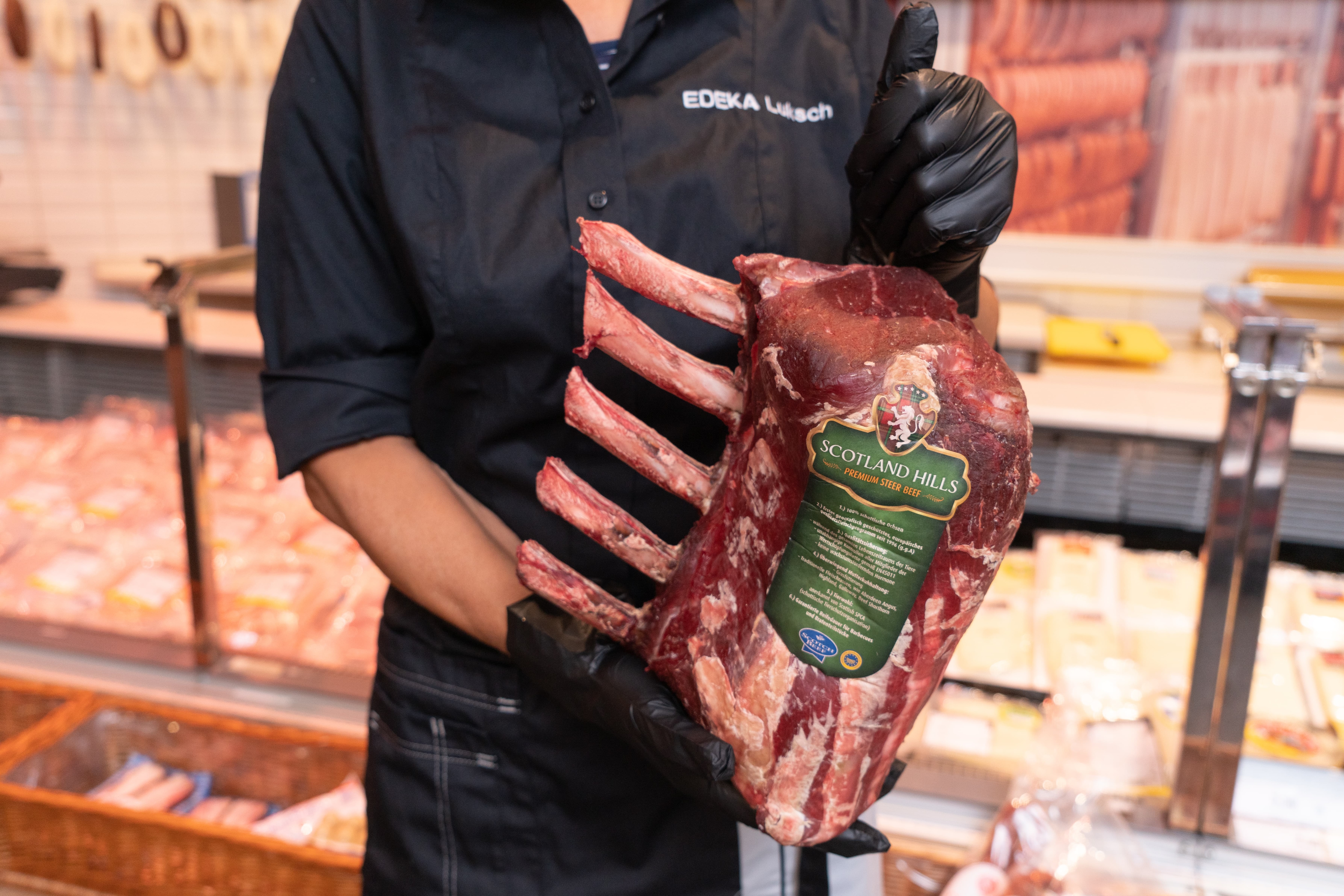 Ein Mitarbeiter hält ein großes Stück Fleisch in den Händen.