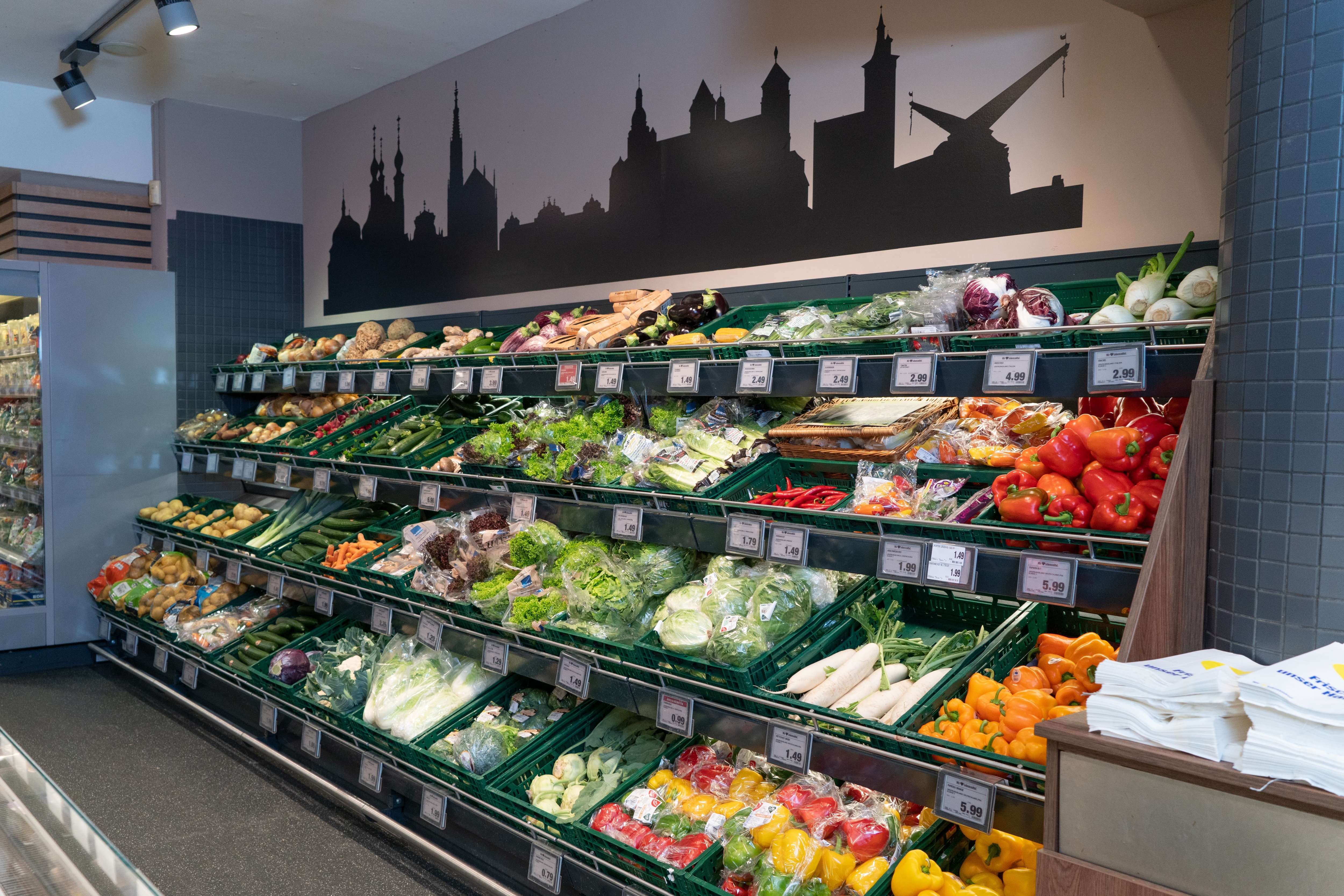 Ein Regal mit Kisten voller verschiedener Gemüsesorten.