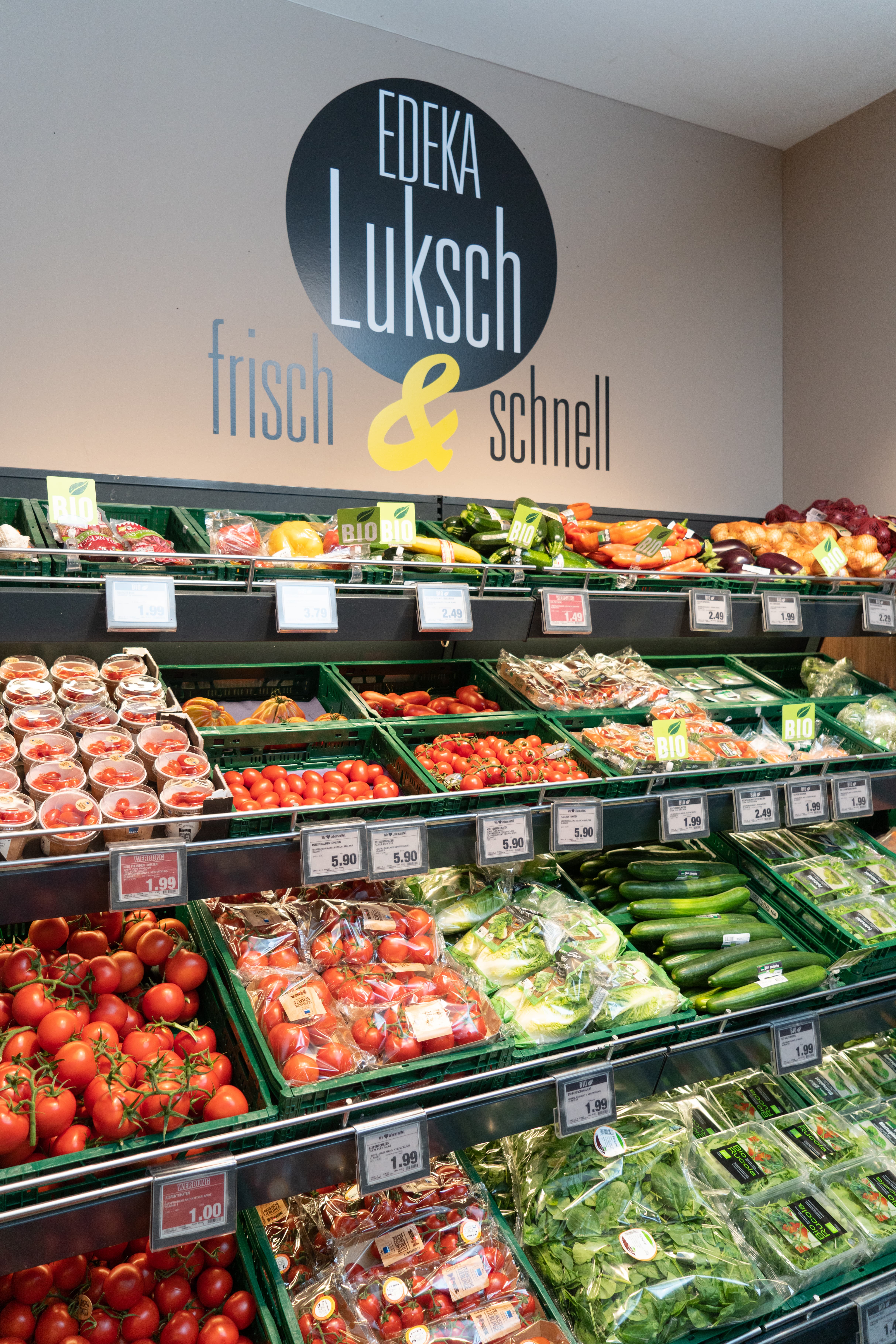 Ein Gemüseregal mit Kisten voller verschiedener Gemüsesorten.