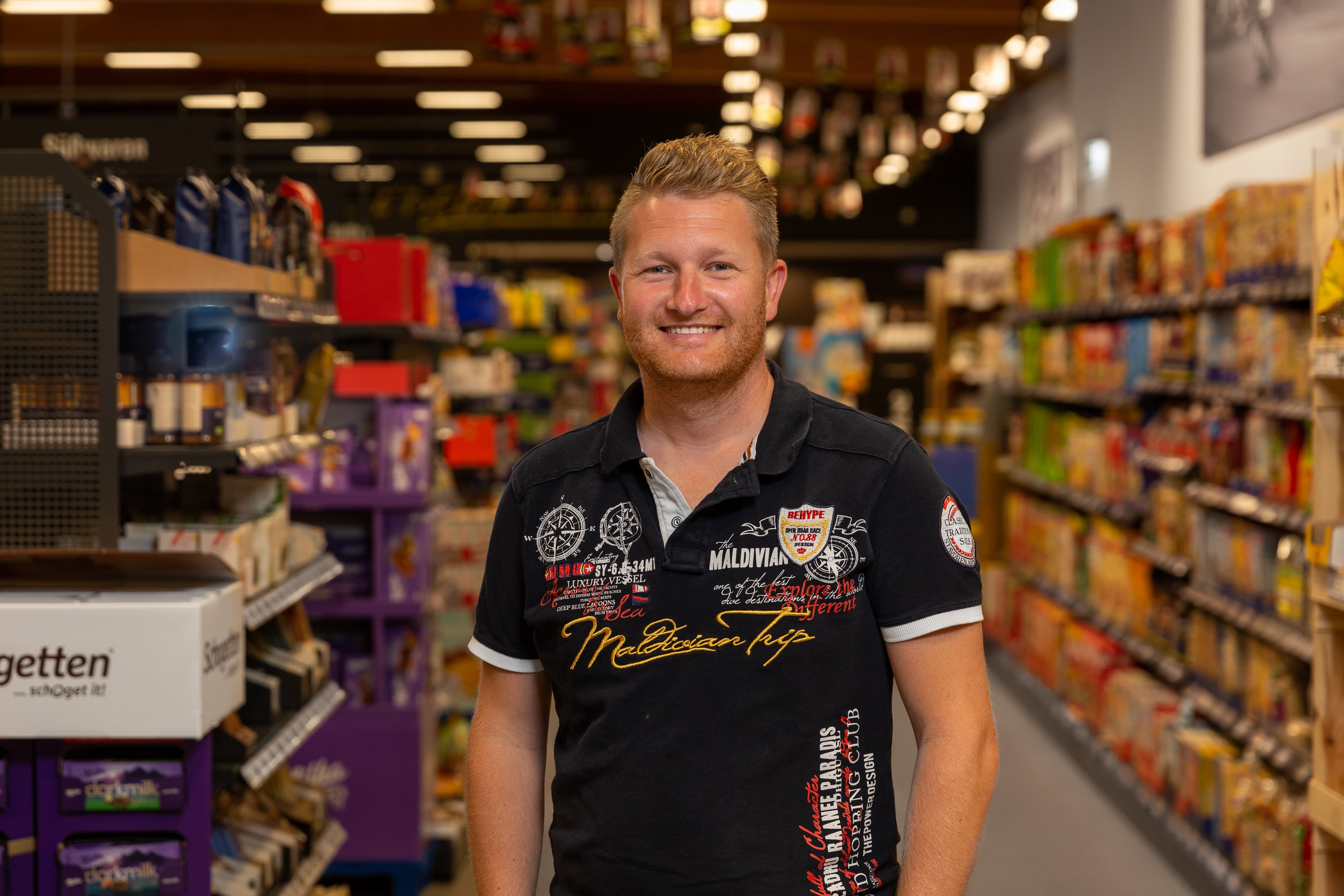 Der Inhaber eines Edeka-Marktes lächelt in die Kamera.