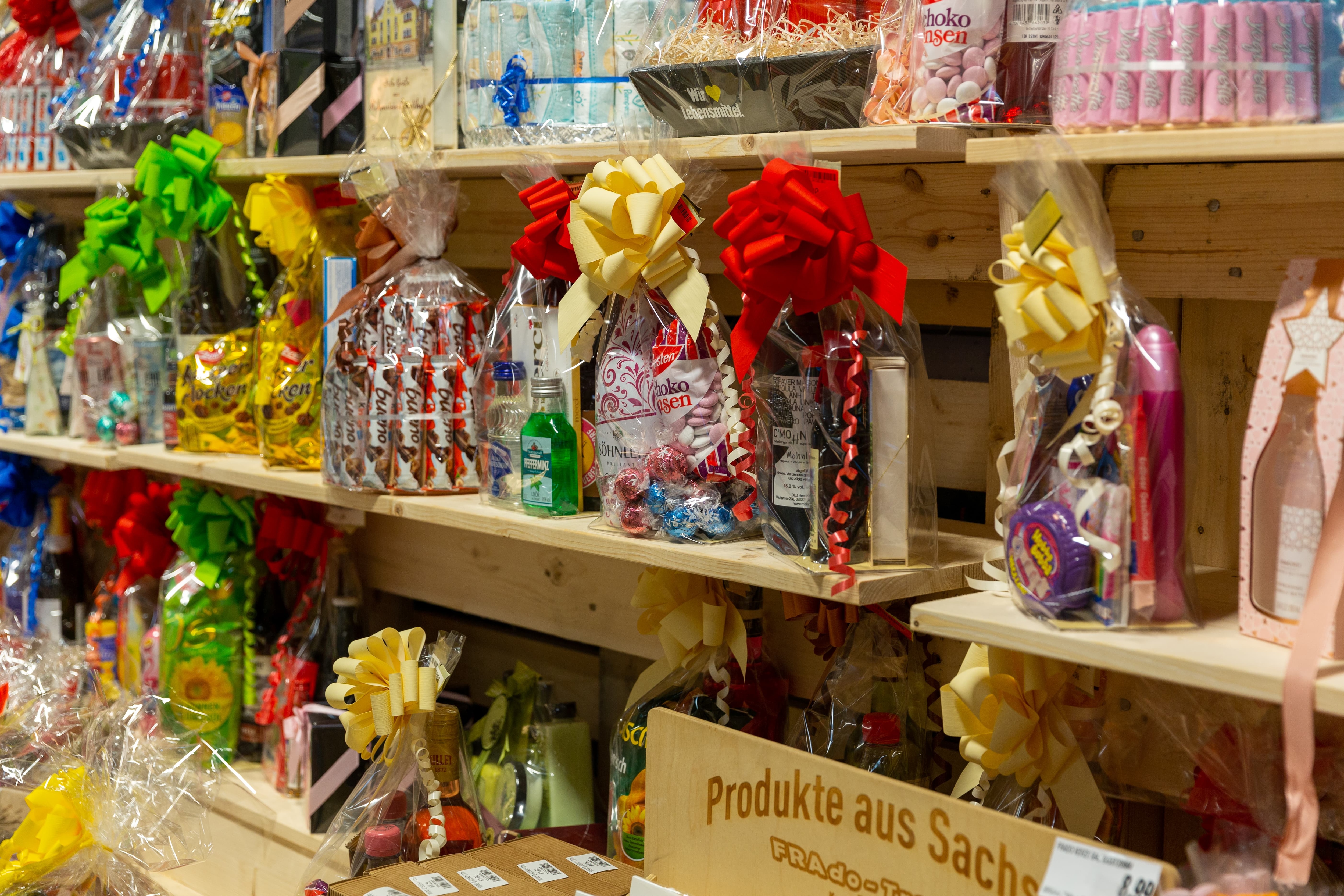 Ein Holzregal mit verschiedenen kleinen Präsent-Tüten und -Körben.