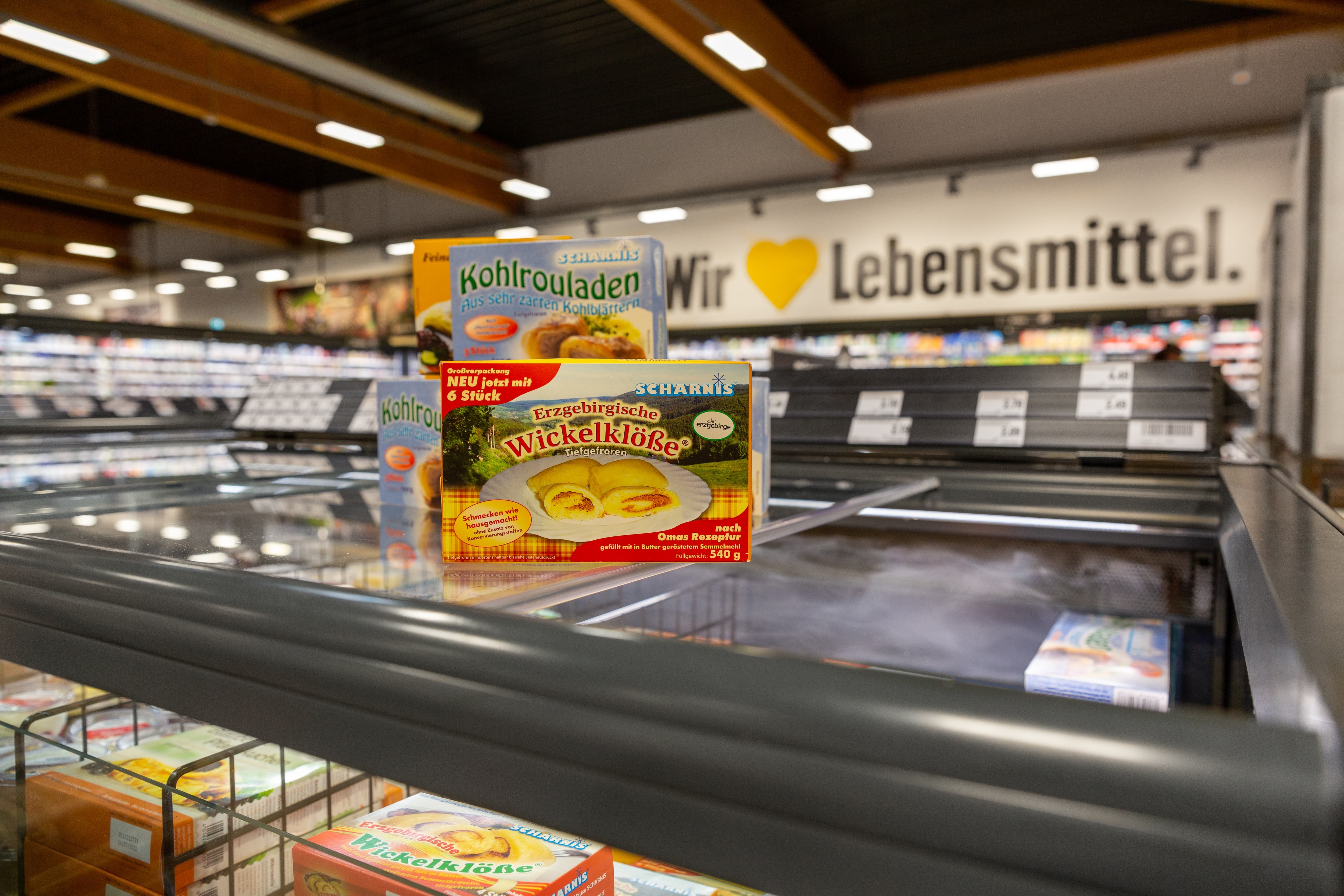 Zwei Packungen Tiefkühl-Kohlrouladen sowie eine Packung Tiefkühl-Wickelklöße drapiert auf einer Tiefkühltruhe eines Edeka-Marktes.