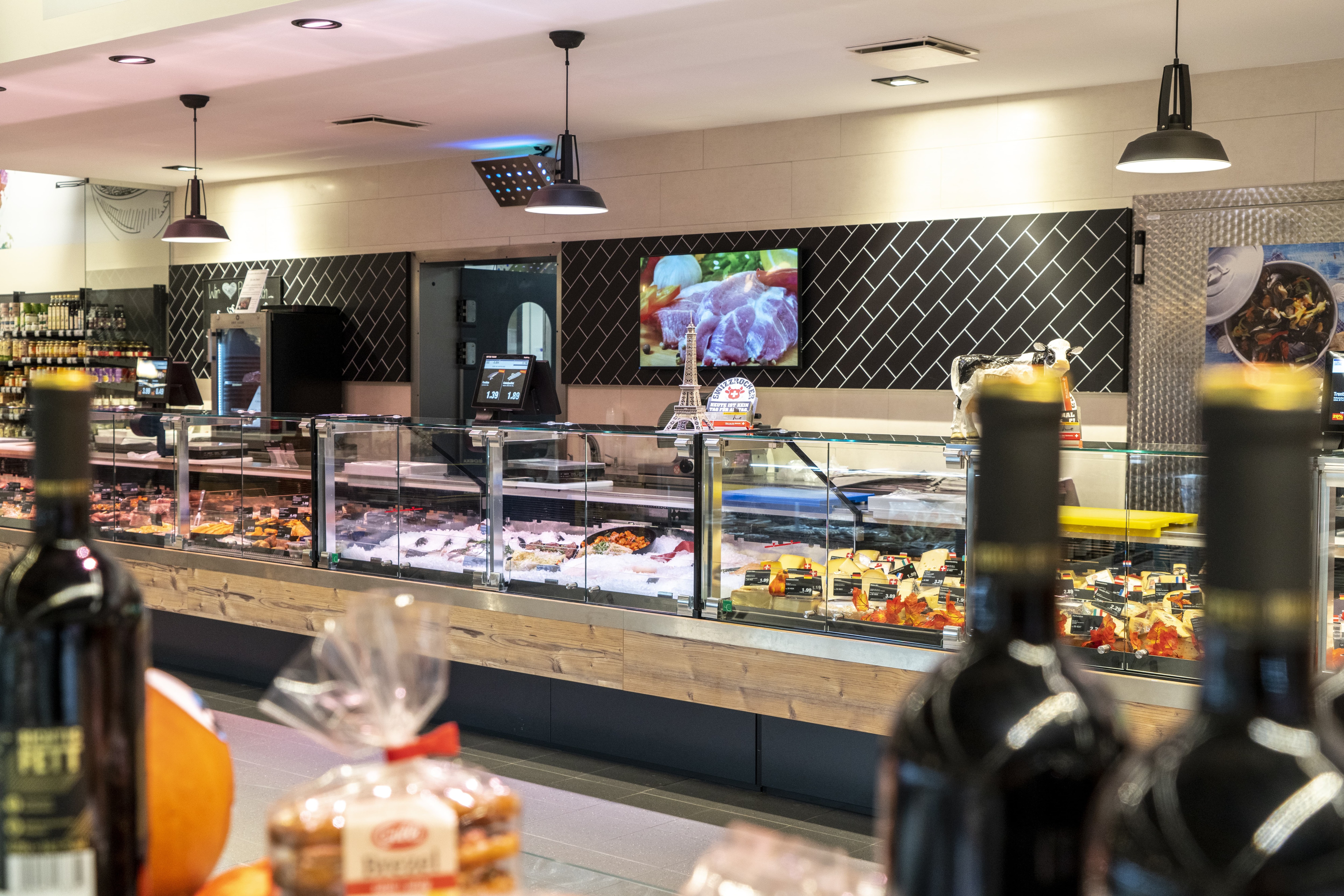 Die Bedientheke eines EDEKA-Markts, im Vordergrund Flaschen.