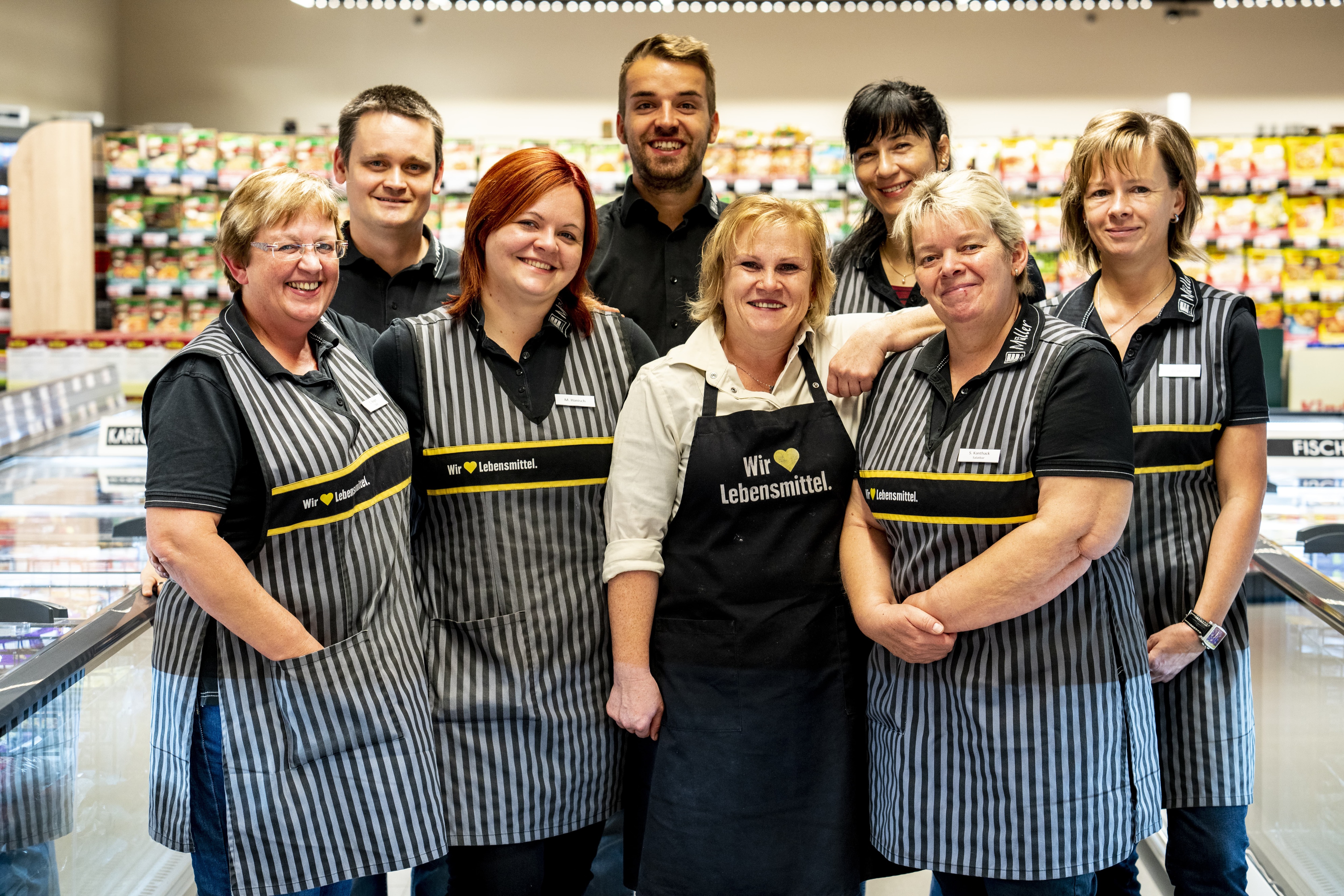 Gruppenfoto des Teams dieses EDEKA-Markts, aufgenommen im Gang im Tiefkühlbereich.