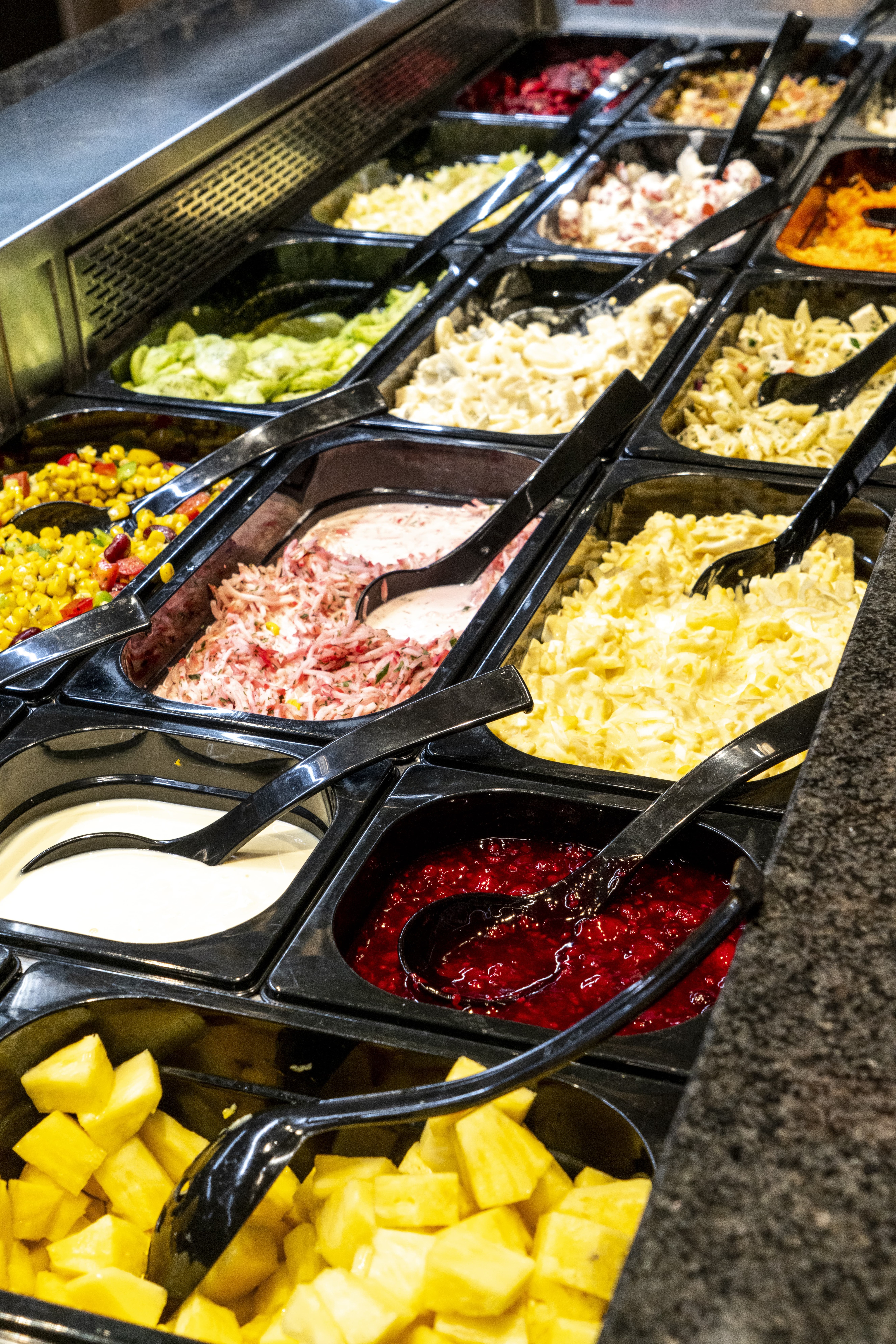 Die Salatbar in einem EDEKA-Markt, reich bestückt mit Nudelsalat, Gurkensalat und anderen.