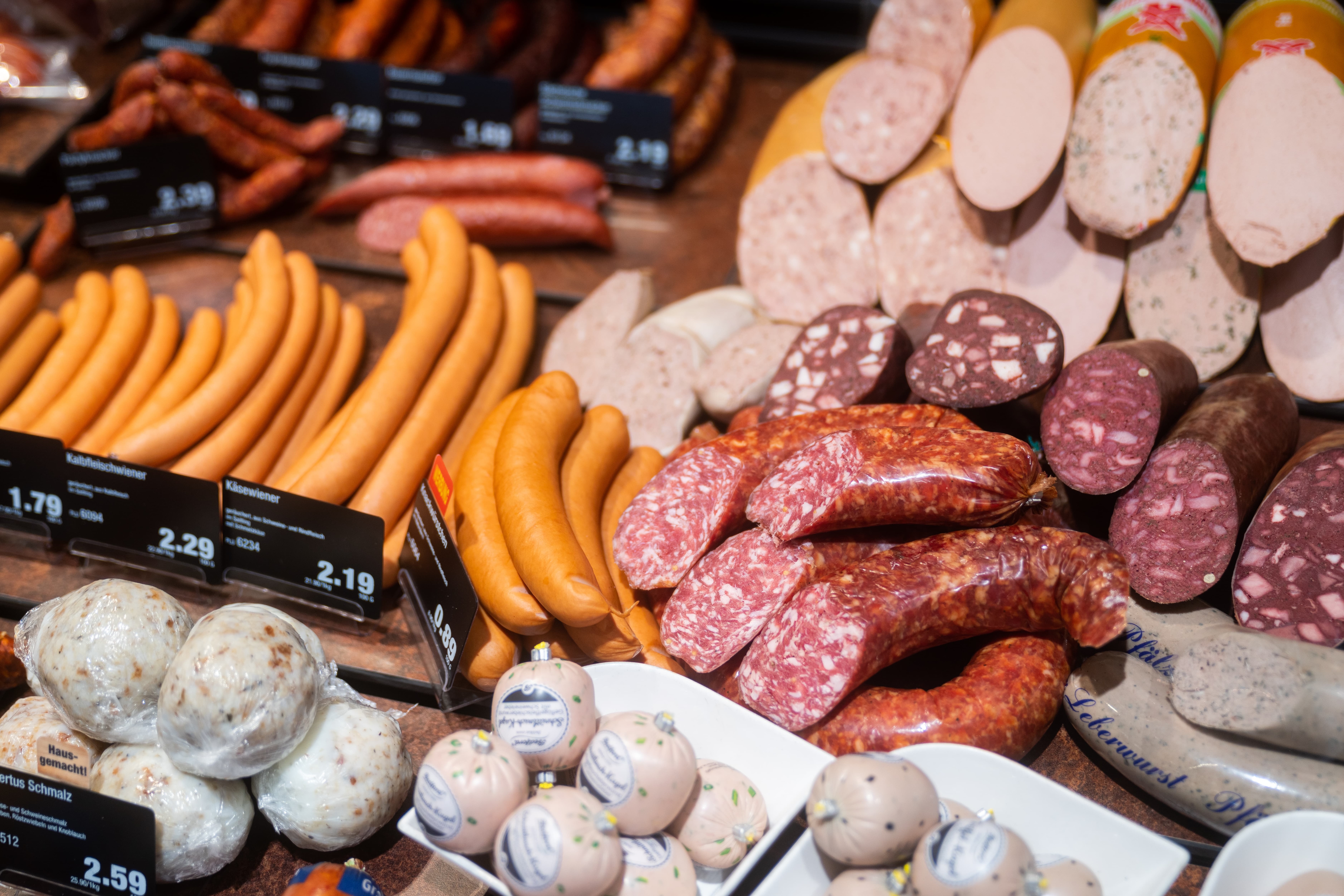 Verschiedene Sorten Streich- und Schnittwurst in einer Auslage.