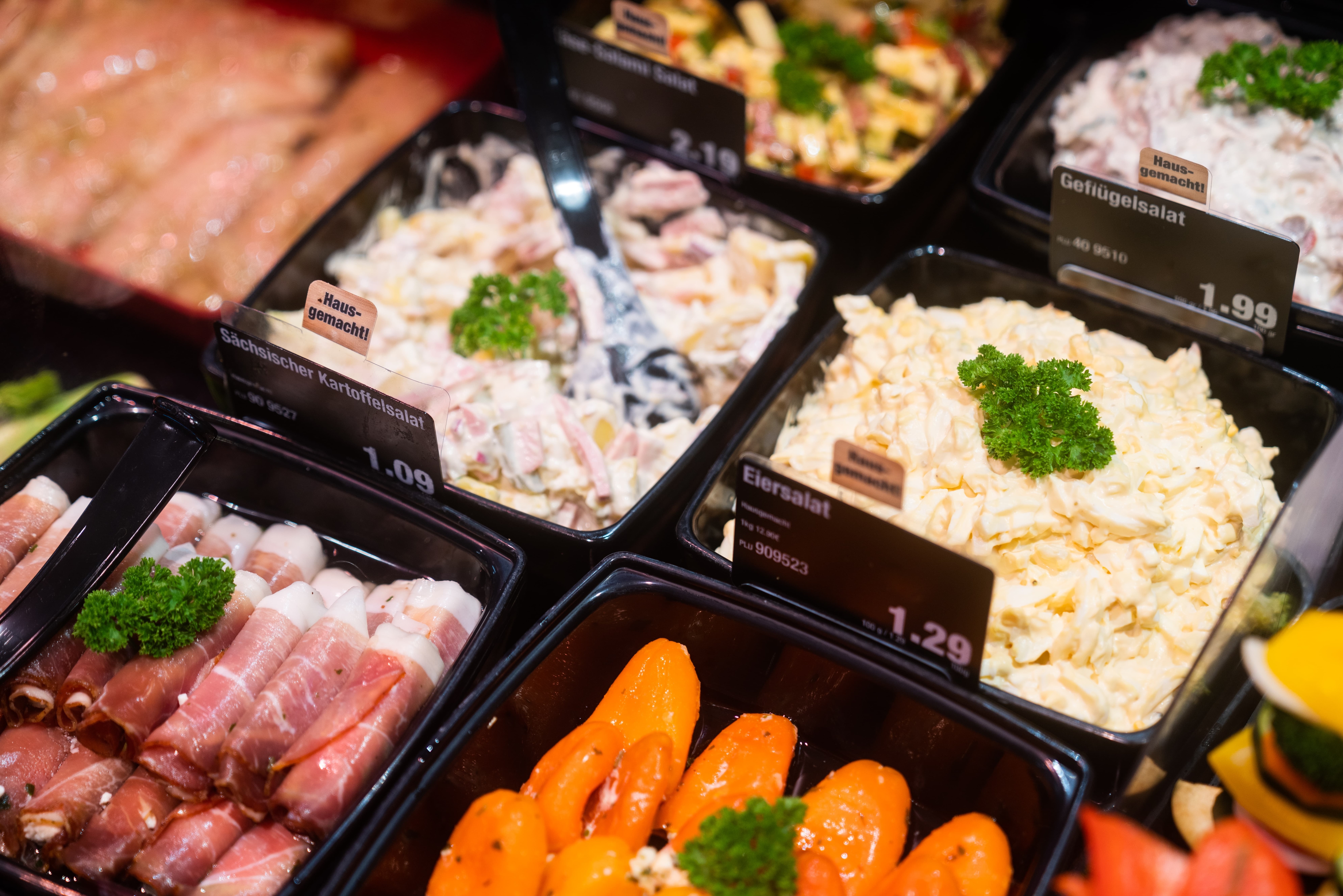 Schwarze Schälchen in der Salatbar mit Sächsischem Kartoffelsalat, Eiersalat und Schinkenröllchen.
