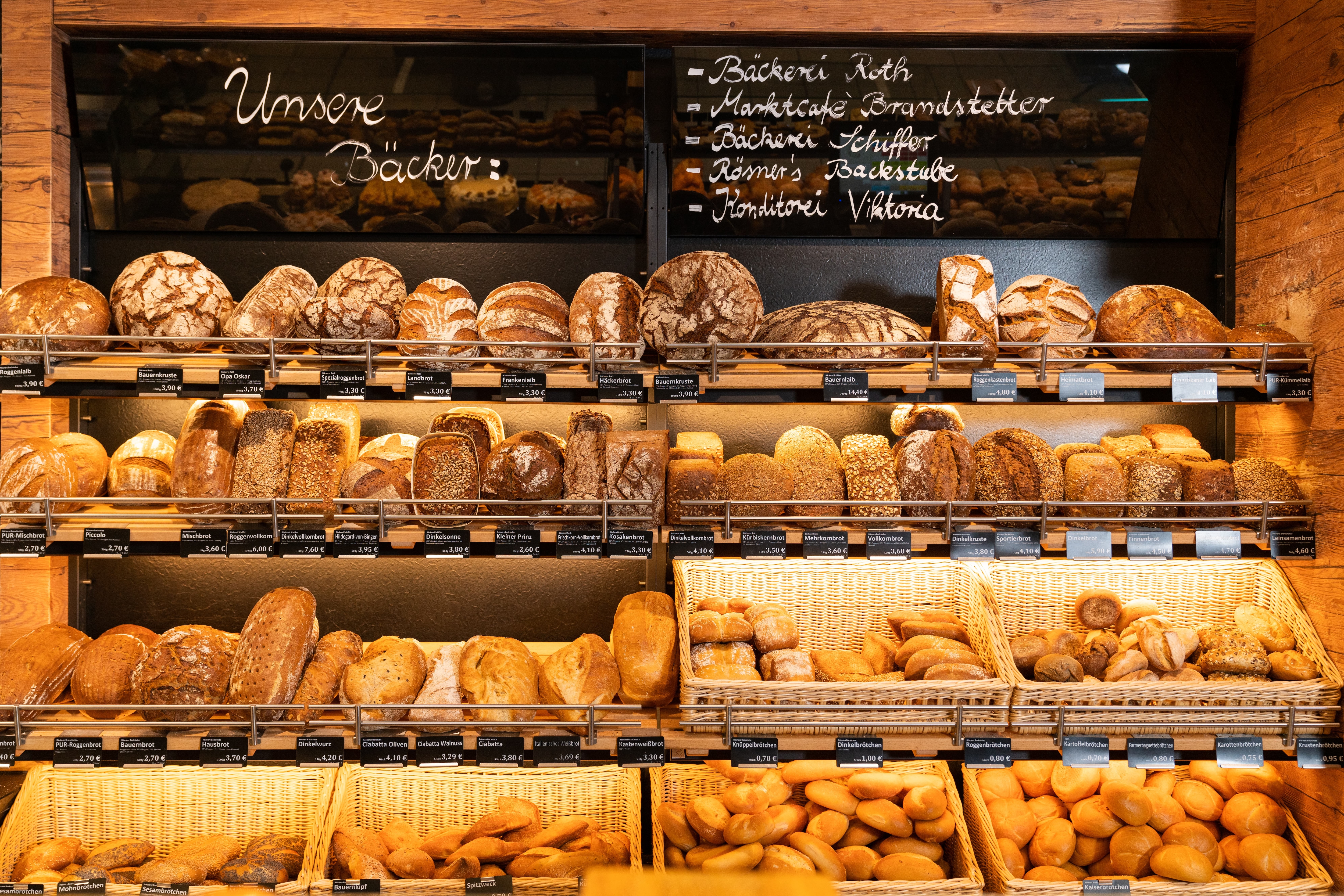 Brotregal beim Bäcker sowie Körbe mit Brötchen.