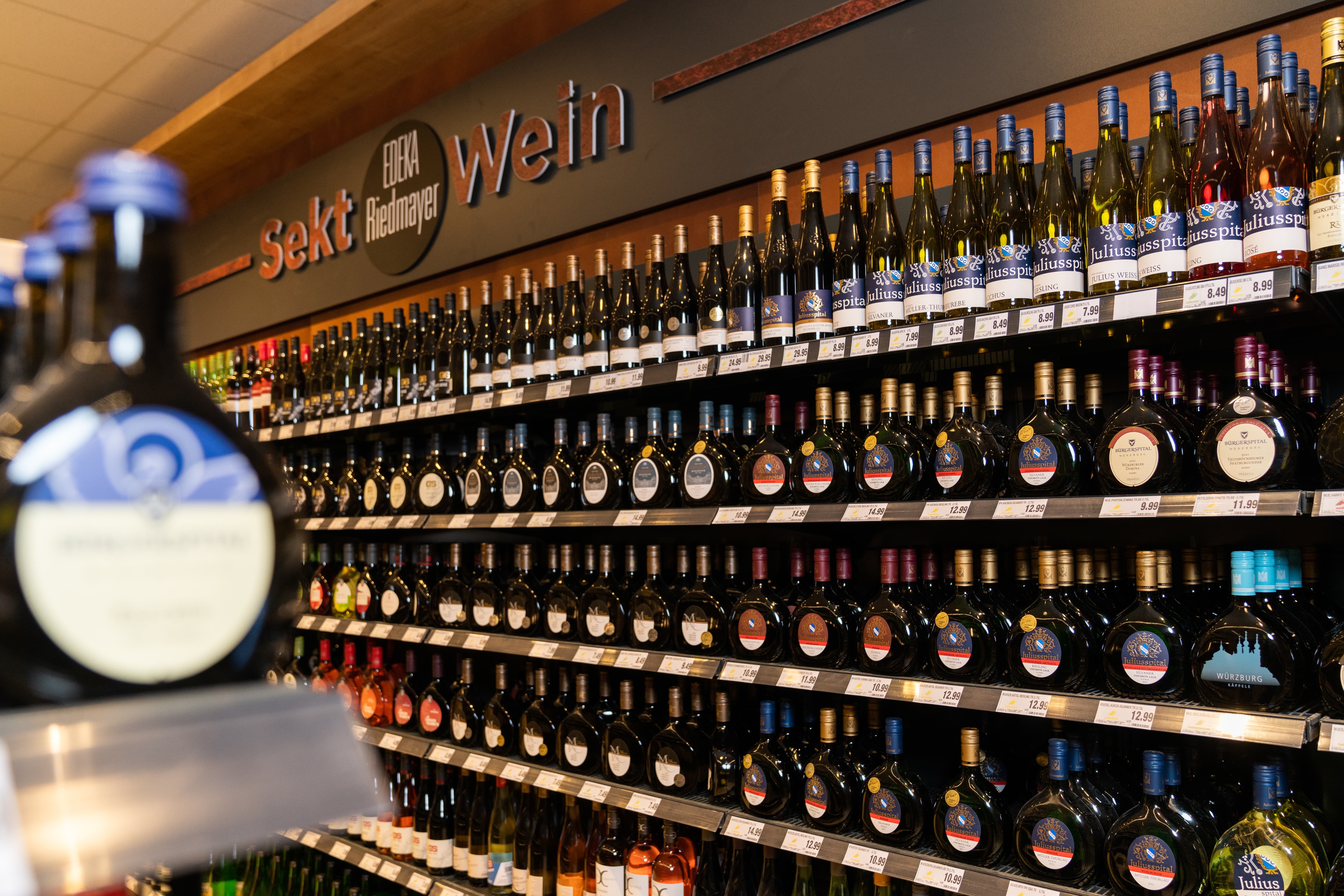 Regal mit dunklen Weinflaschen.