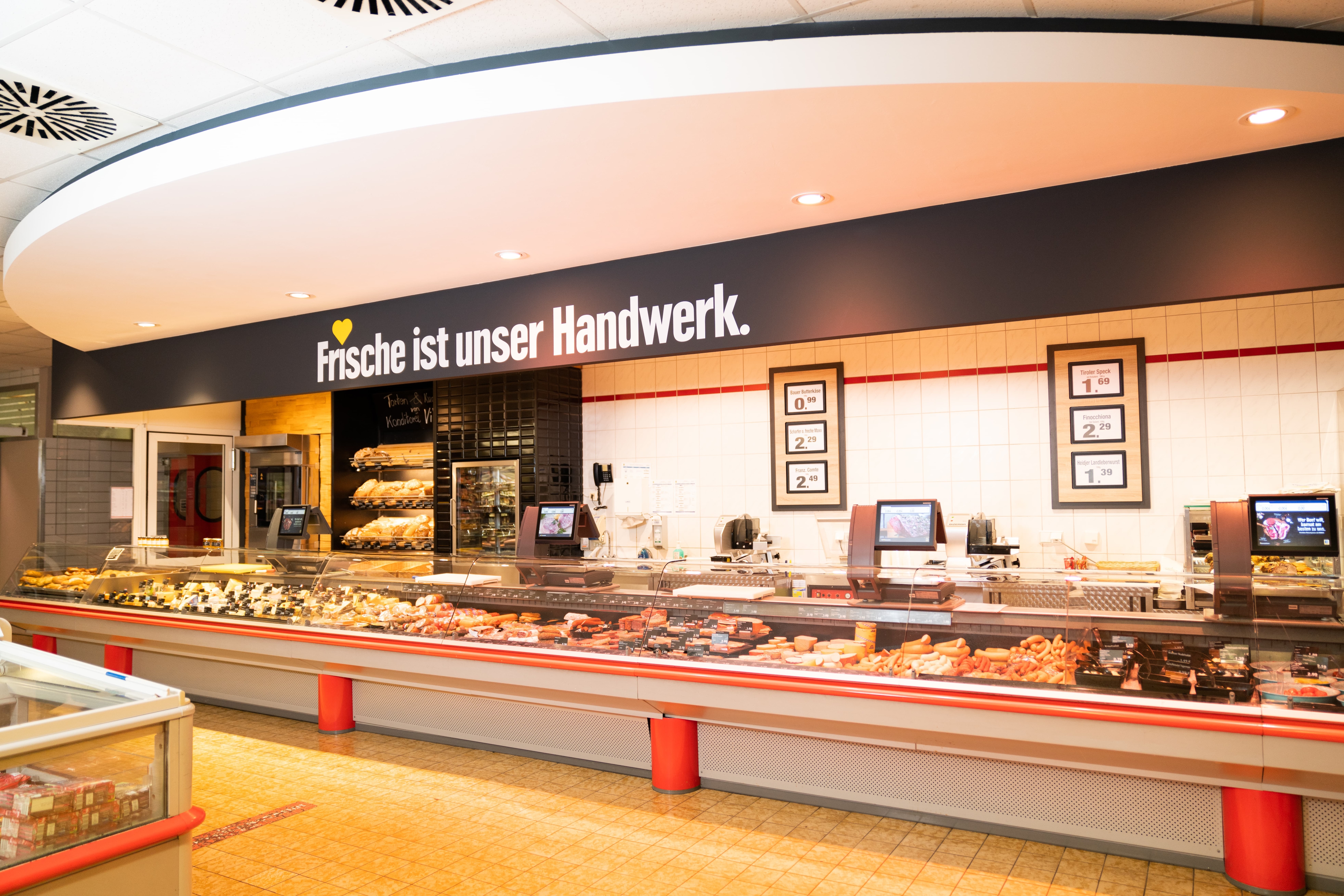 Über der Frischetheke ist ein großer Schriftzug: Frische ist unser Handwerk.