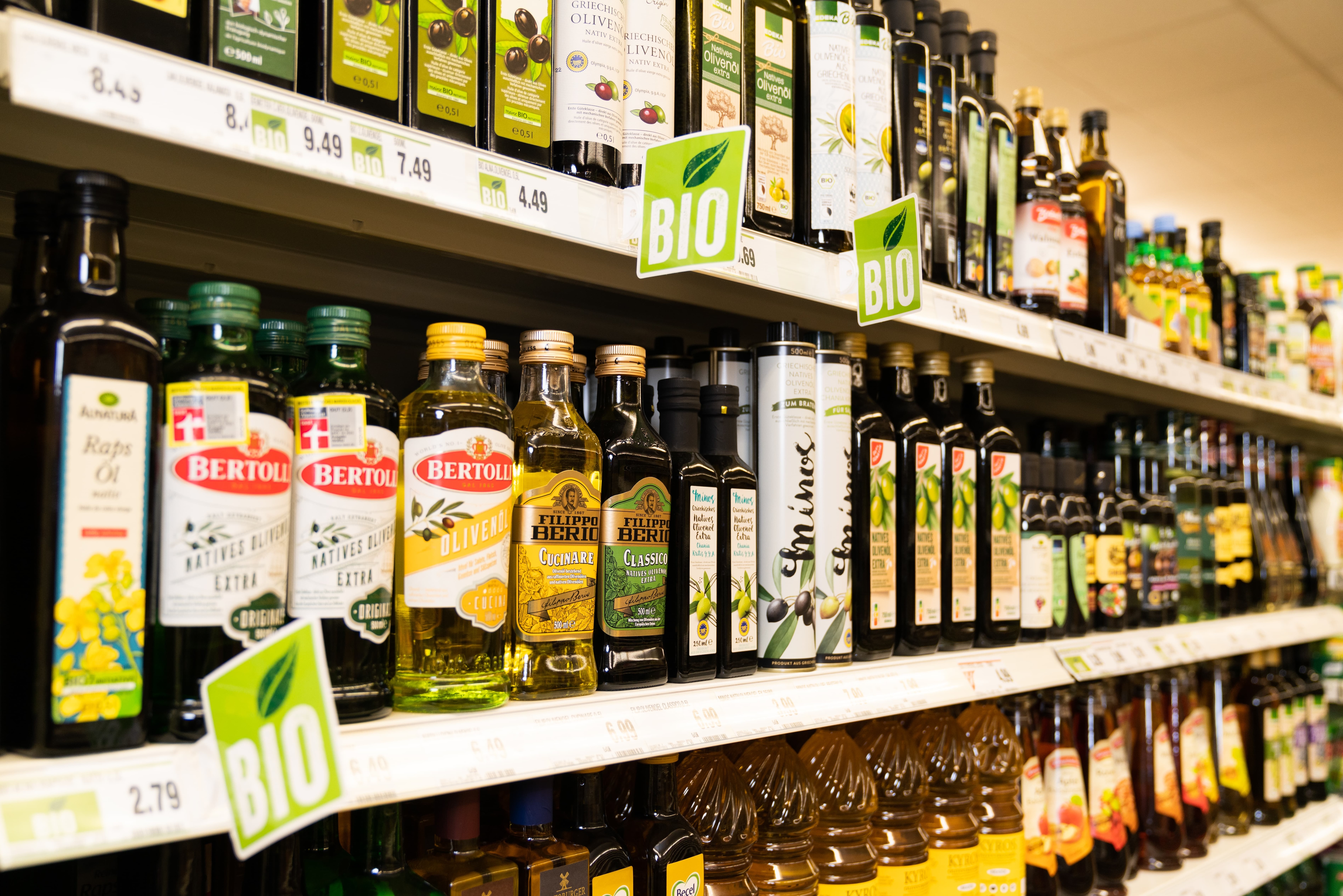 Speiseöle in einem Regal. Neben den Preisschildern sind grüne BIO-Labels.
