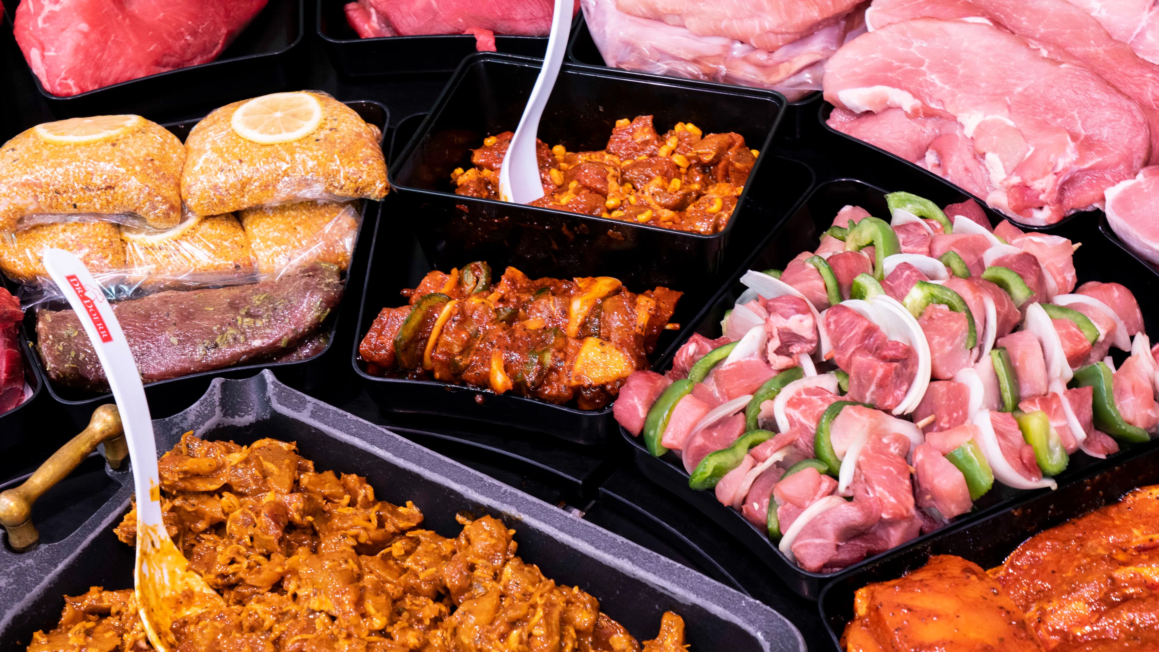 Nahaufnahme verschiedener Fleischprodukte in der Auslage einer Bedientheke.