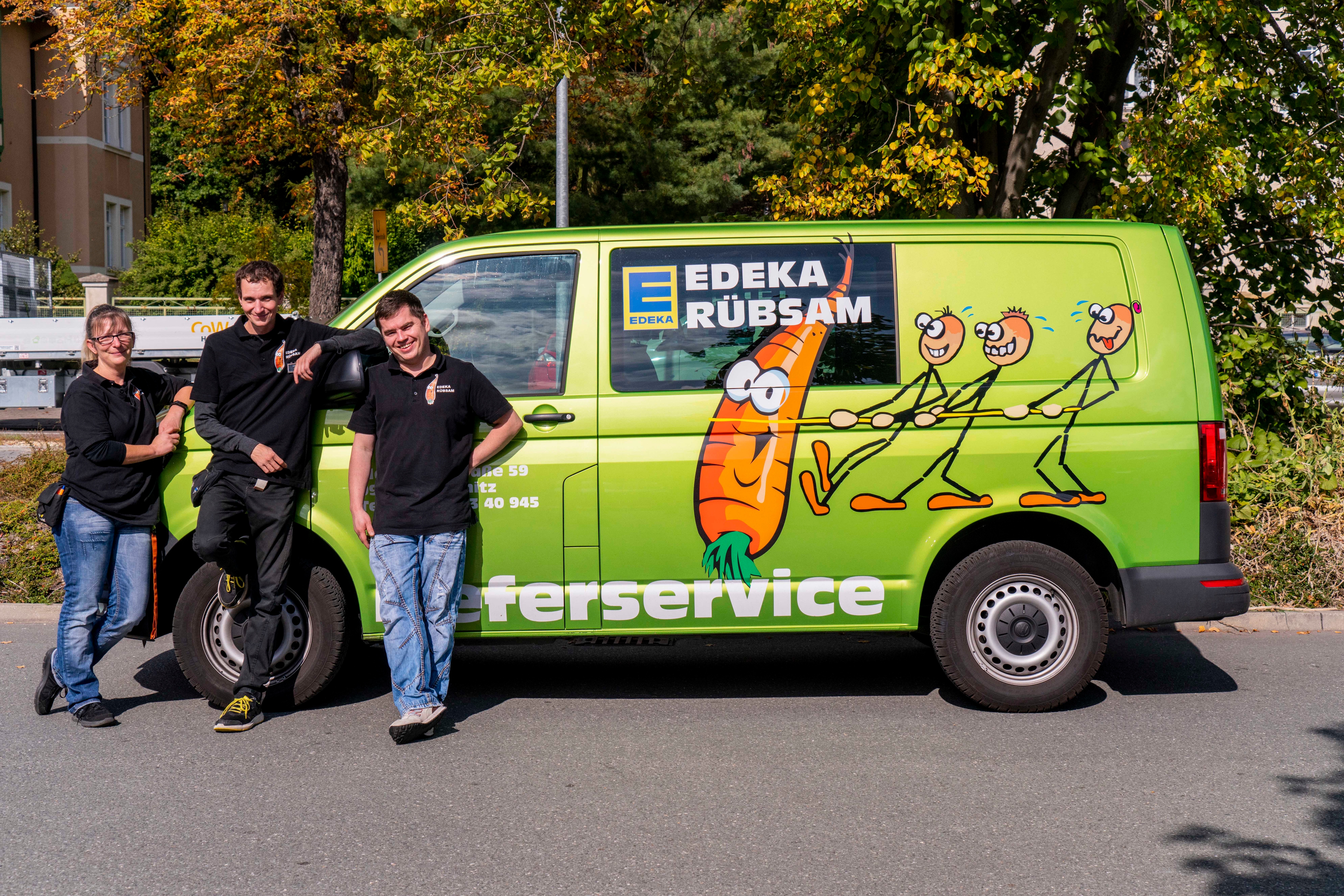Drei Personen lehnen an dem Lieferwagen von Edeka Rübsam.