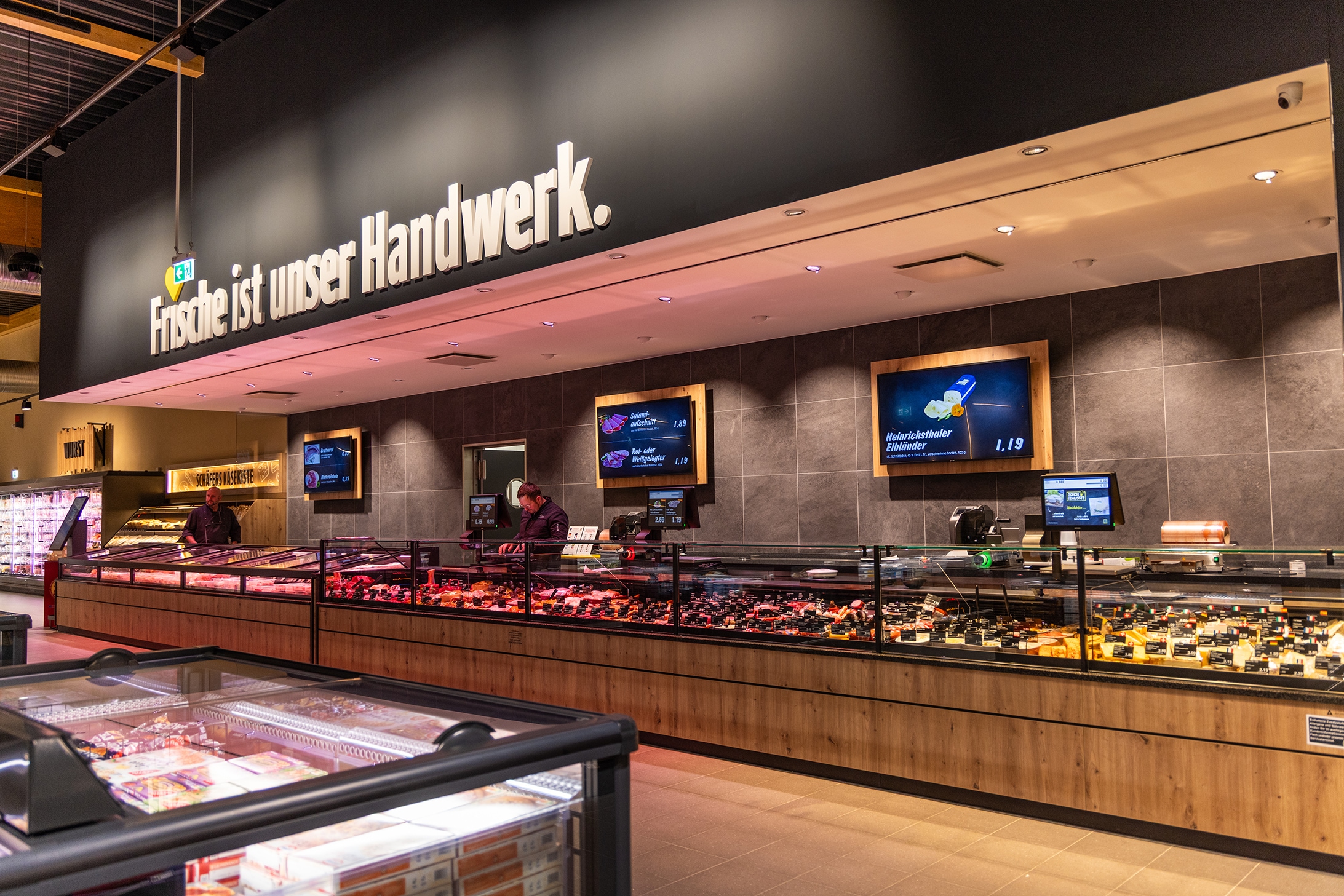 Gesamtüberblick über die Frischetheke mit Wandgestaltung oben drüber "Frische ist unser Handwerk".