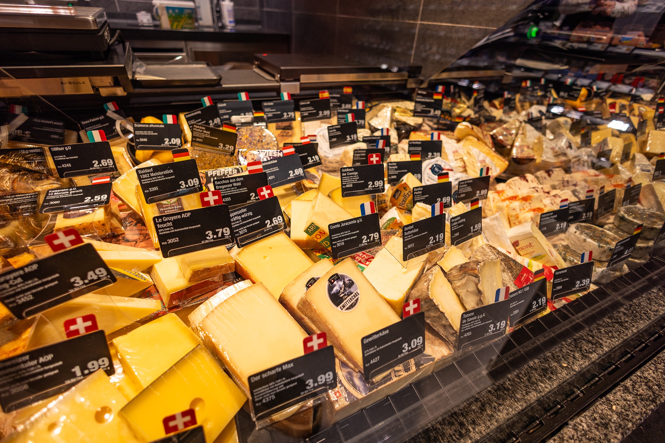 In der Auslage der Frischetheke sind viele Käsesorten aus den unterschiedlichsten Ländern.