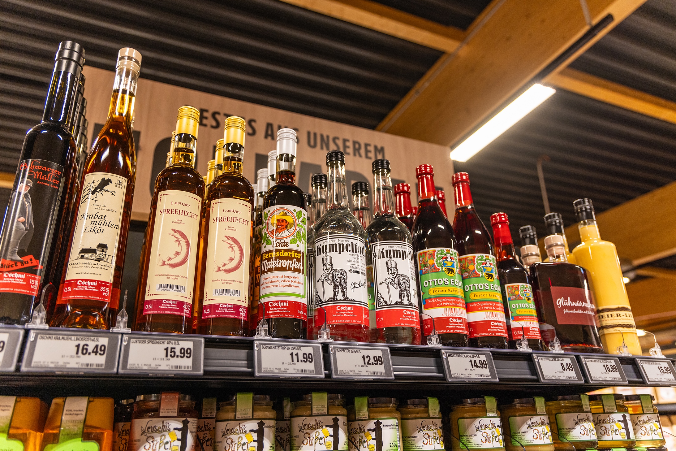 Verschiedene regionale Liköre und Schnapsflaschen im Regal.