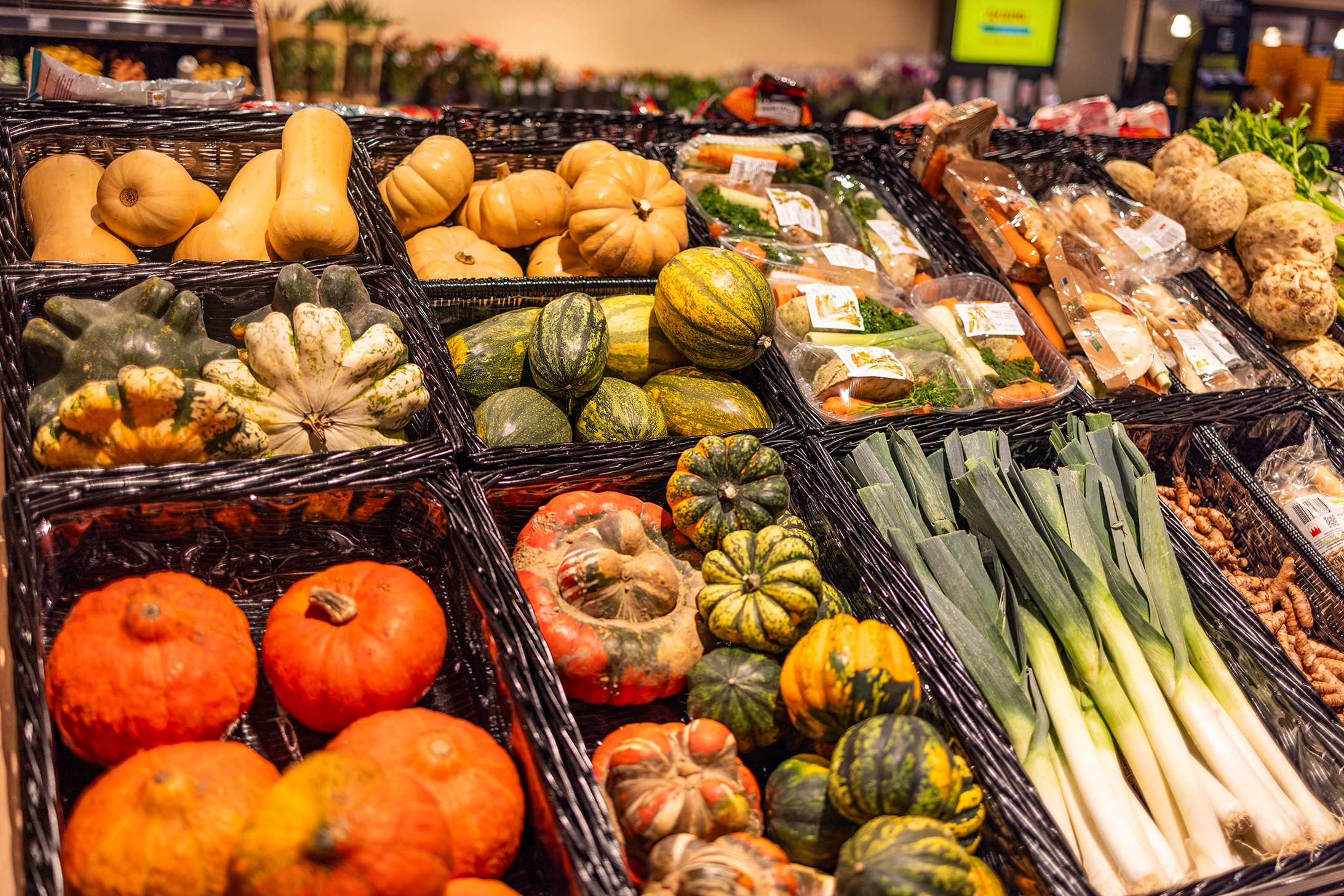 In der Auslage in Körben befinden sich verschiedene Sorten an Kürbissen und Lauch.