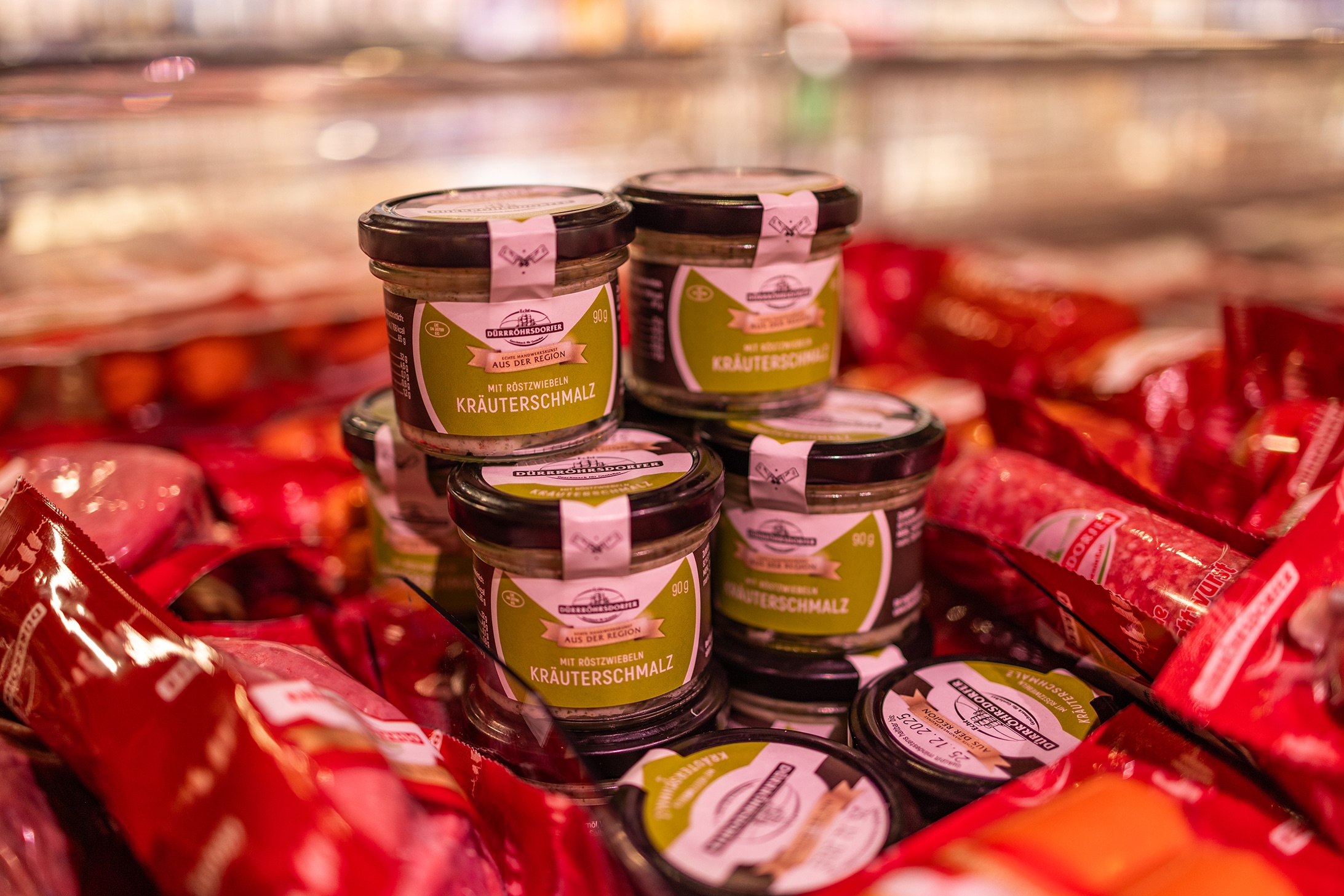 Kräuterschmalz in Gläsern von einem regionalen Erzeuger ist aufgestapelt.