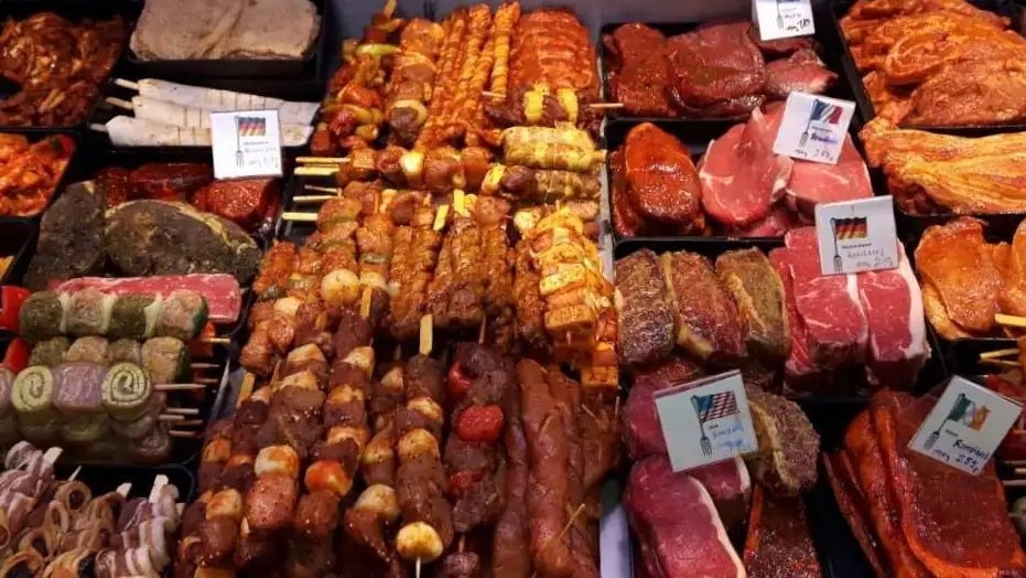 Verschiedene Grillprodukte in der Auslage einer Fleischtheke.