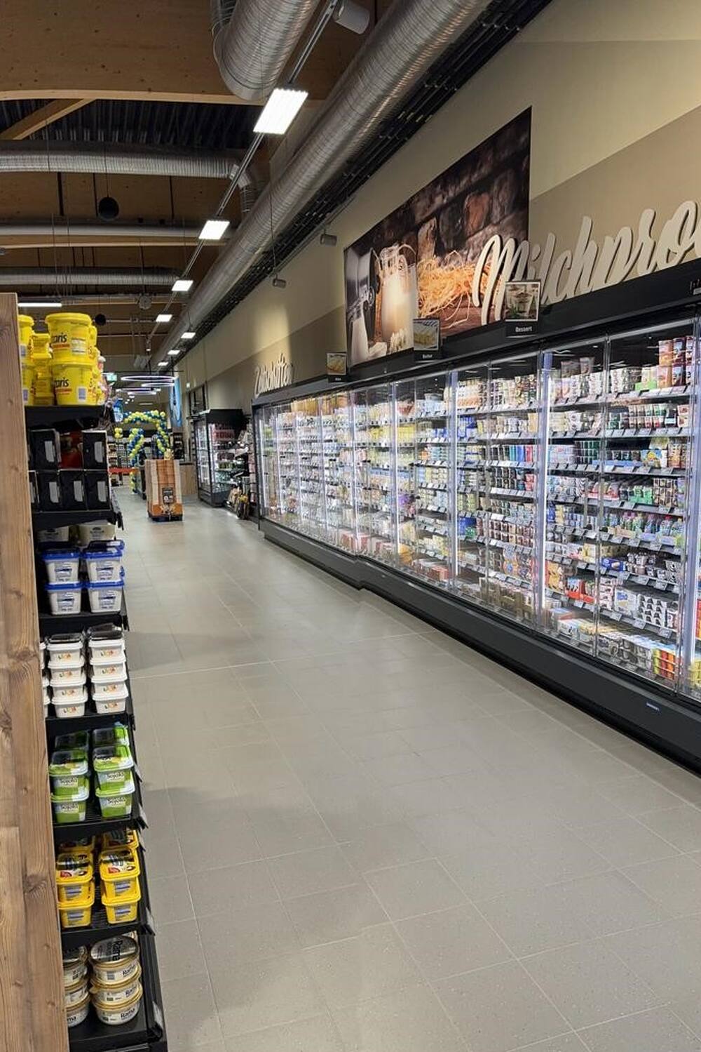Blick entlang eines Kühlregals mit Molkereiprodukten.