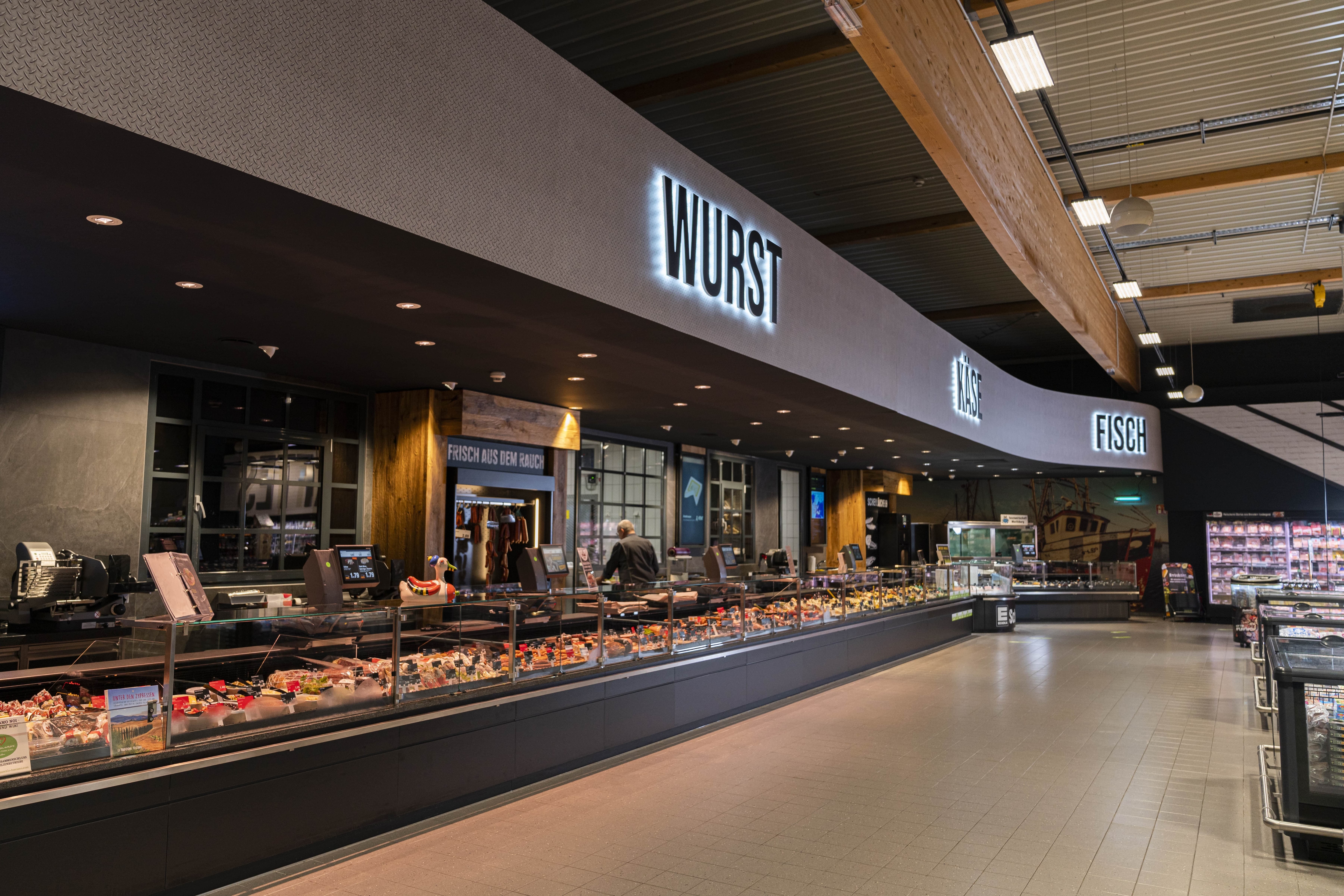 Über der Frischetheke steht in Leuchtbuchstaben: Wurst, Käse, Fisch.