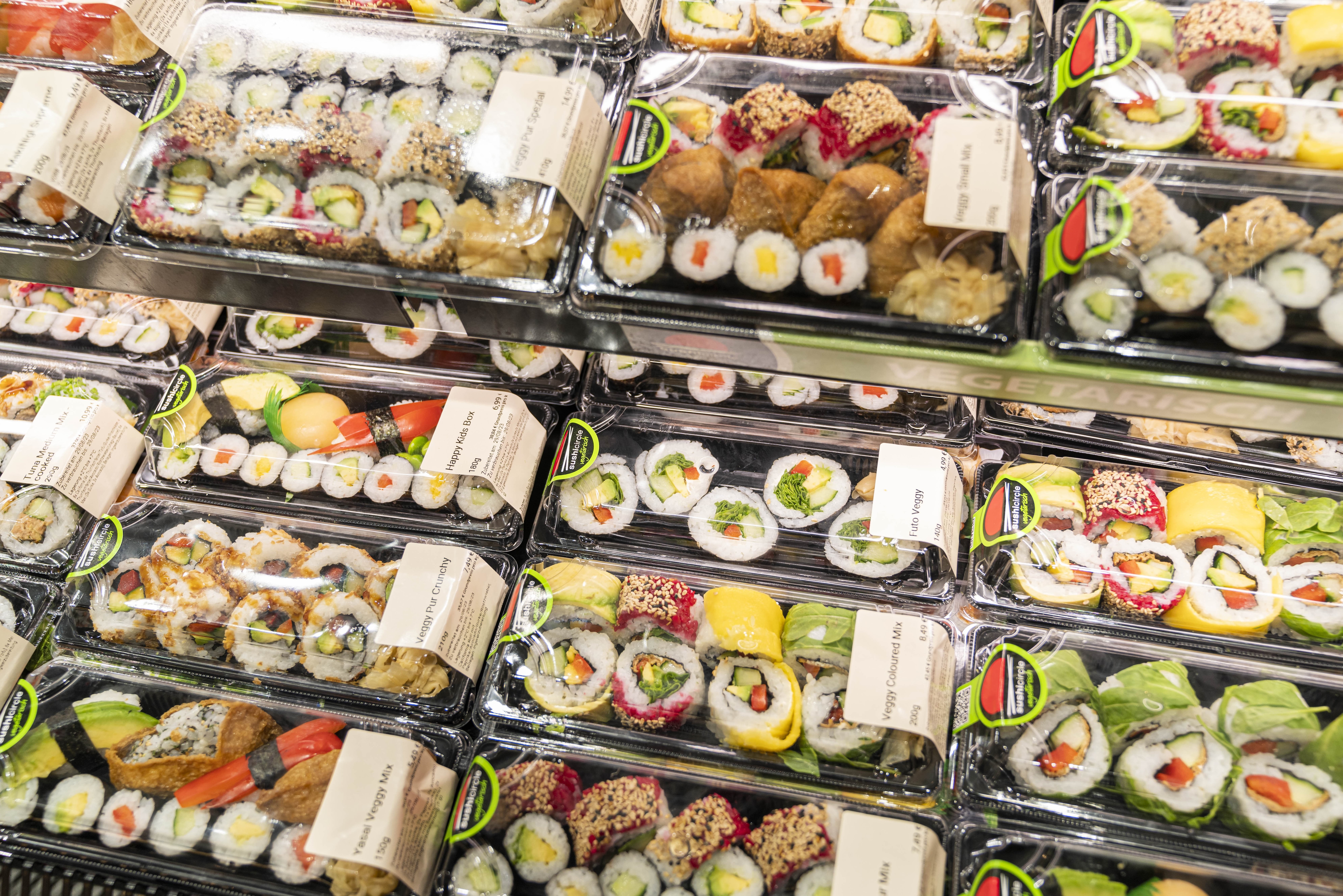 Sushi-Varianten in Einweg-Behältern aus Plastik.