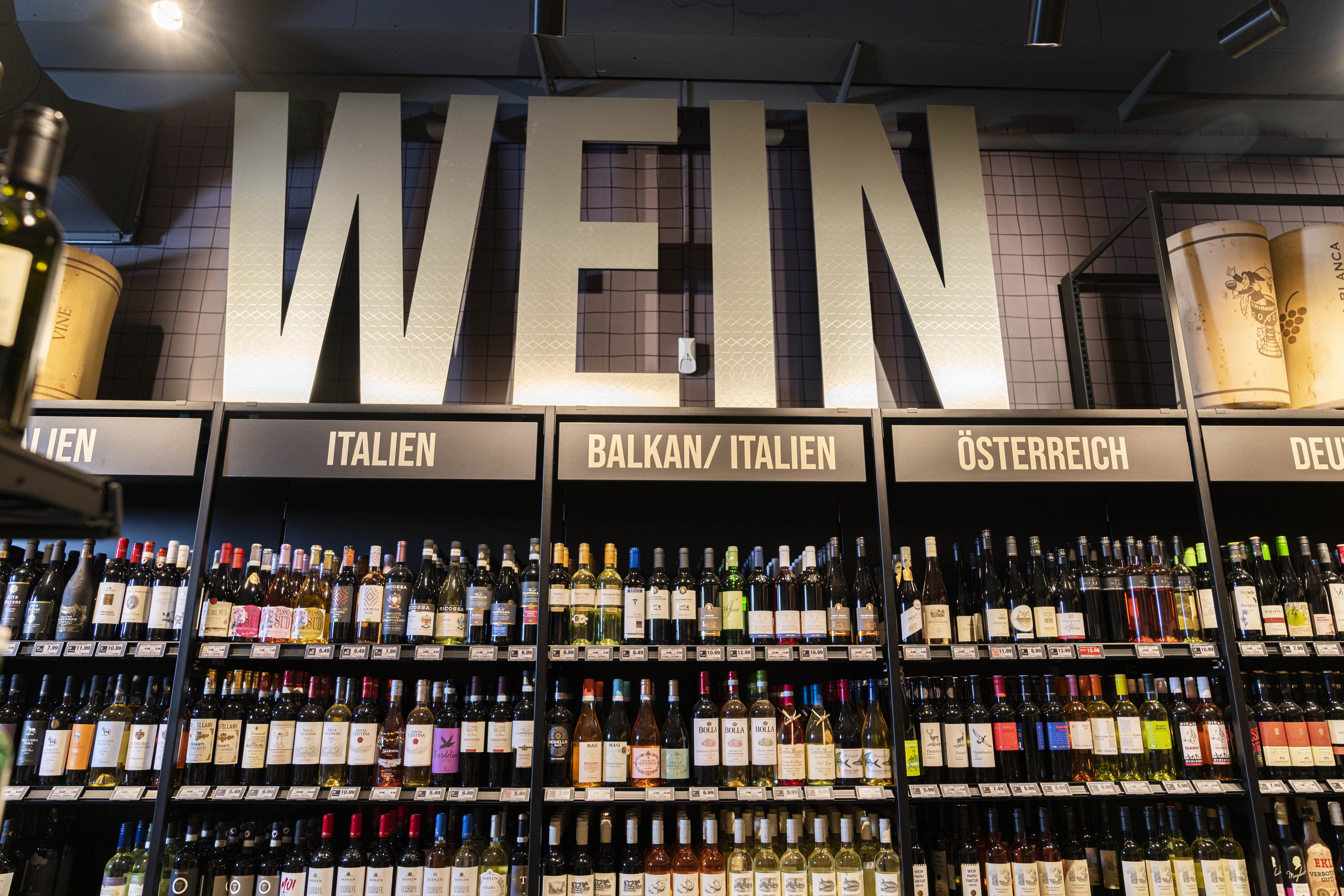 Weinregale mit den Titeln Italien, Balkan/Italien, Österreich und Deutschland.