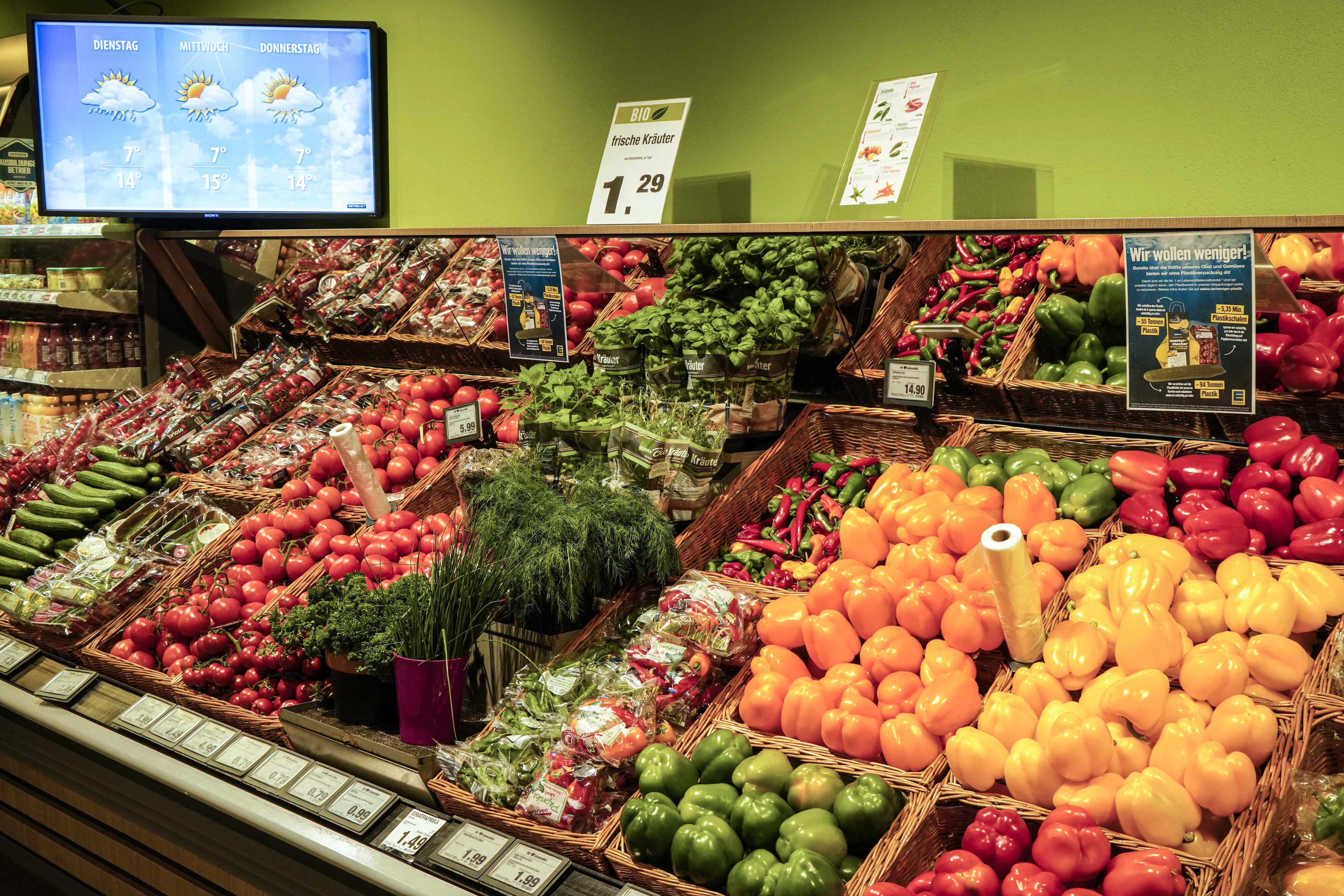 Gemüseabteilung mit frischen Kräutern und Paprika.