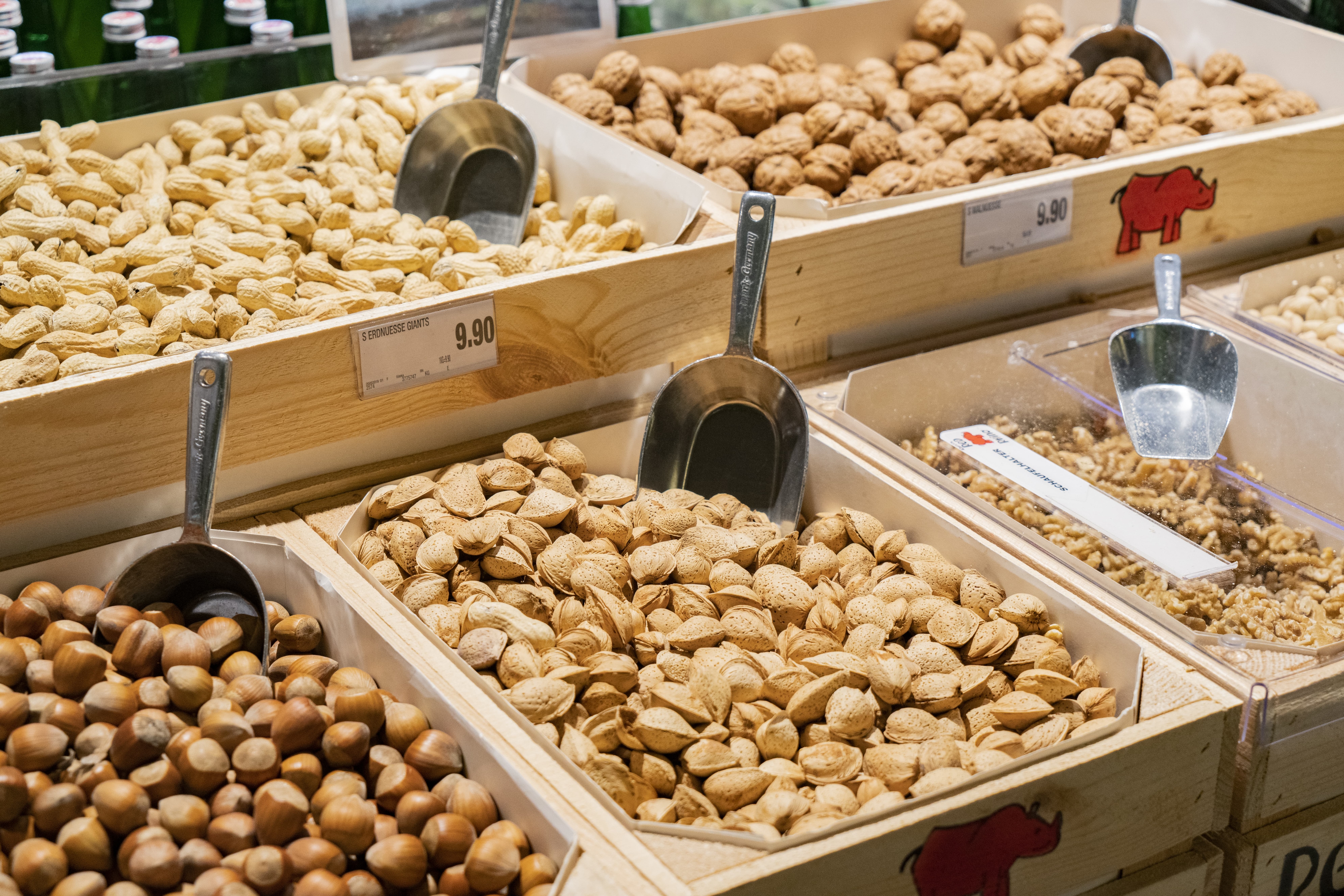 Holzkisten mit Nüssen und silbernen Schaufeln.